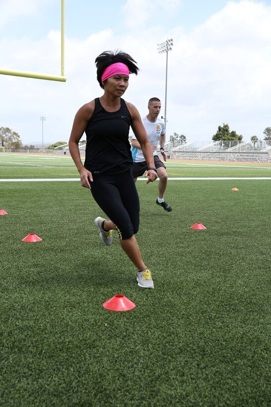 Petty Officer 1st Class Thea Cortez, dental laboratory tech, 1st Dental Battalion, runs through agility drills during High Intensity Tactical Training aboard Camp Pendleton, Calif., May 7, 2014. HITT focuses on tactical athletes and involves injury prevention, dynamic warm-ups, strength and power components, speed and agility, endurance, flexibility and core stability.