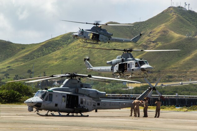 Marines with Marine Light Attack Helicopter Squadron 367 begin prepping a UH-1Y Huey helicopter for takeoff as two others prepare to land aboard Marine Corps Air Station Kaneohe Bay, Hawaii, May 6, 2014. Marine Aircraft Group 24 conducted a max launch of 11 total UH-1Y Huey and AH-1W SuperCobra helicopters assigned to HMLA-367 and CH-53E Super Stallion helicopters assigned to Marine Heavy Helicopter Squadron 463 in an effort to increase unit cohesion and camaraderie within the MAG. While HMLA-367 and HMH-463 conducted operations in the air, Marine Wing Support Detachment 24 and Marine Aviation Logistics Squadron 24 were on the ground to provide forward arming and refueling points, giving MAG-24 a chance to work as a whole. After conducting flight operations, the aircraft returned to MCAS Kaneohe Bay and completed their max launch with a flyby over Marine Corps Base Hawaii before landing. (U.S. Marine Corps photo by Lance Cpl. Matthew Bragg)