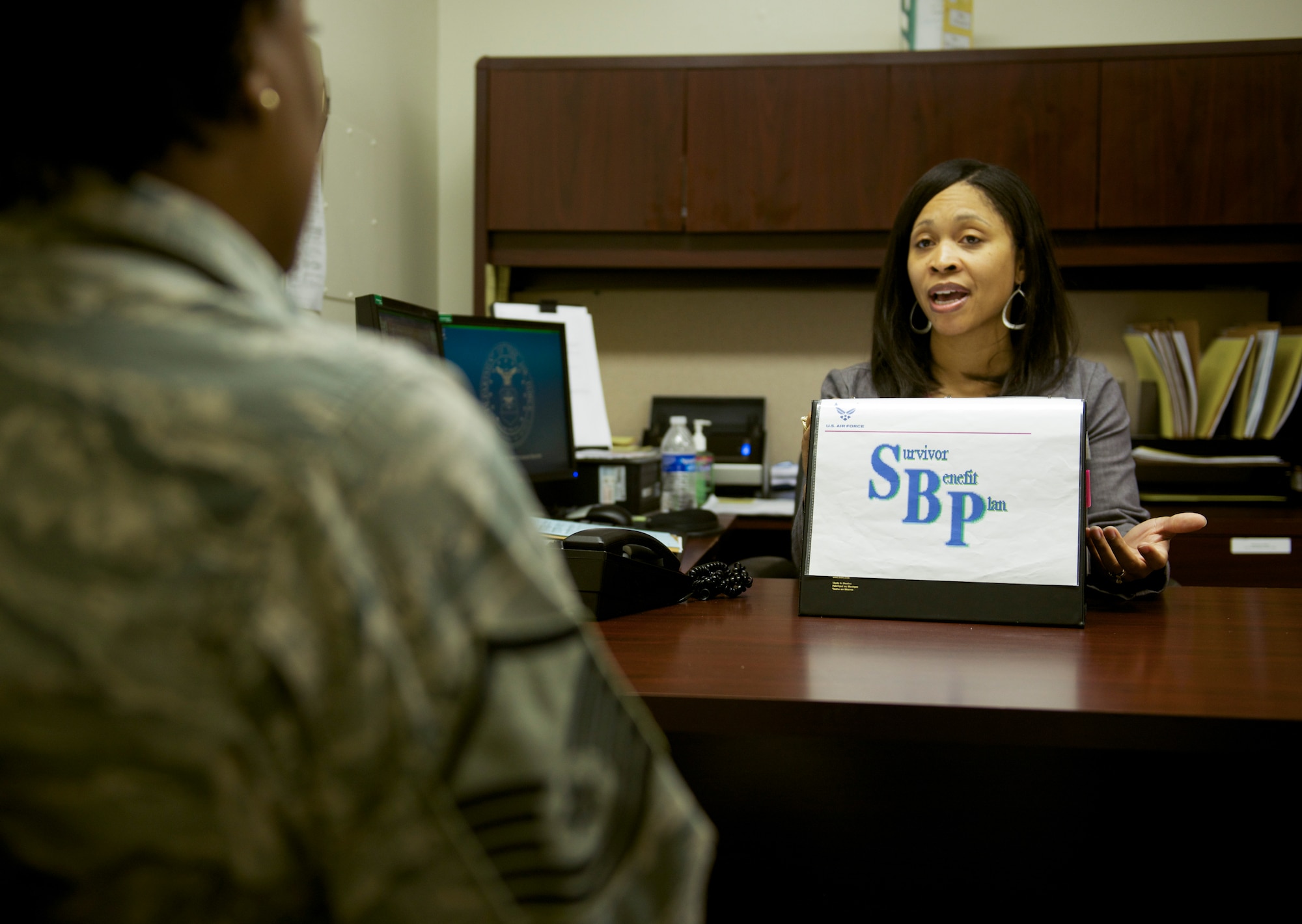 Tanquer Dyer, Yokota Casualty Assistance Representative, explains the survivor benefit plan to a retiring military member at Yokota Air Base, Japan, May 5, 2014. Dyer is serving the military community as a civilian now, but has also previously served enlisted and commissioned tours. (U.S. Air Force photo by Staff Sgt. Cody H. Ramirez)