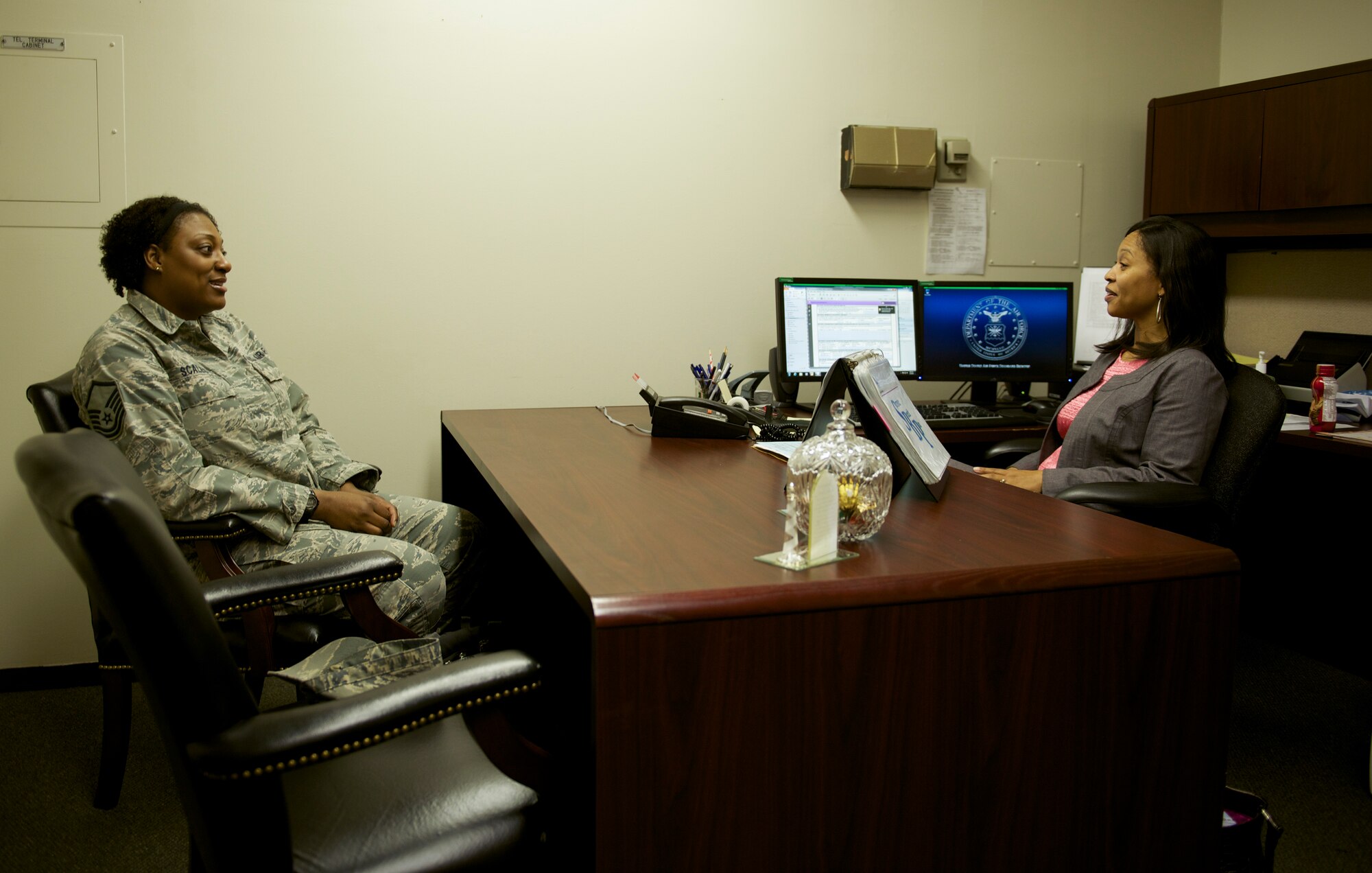 Tanquer Dyer, Yokota Casualty Assistance Representative, talks with Master Sgt. Nigesa Scales who is preparing to retire at Yokota Air Base, Japan, May 5, 2014. In addition to informing retiring military members at Yokota of the benefits available to them and their spouses, Dyer also assists family members of military casualties. (U.S. Air Force photo by Staff Sgt. Cody H. Ramirez)