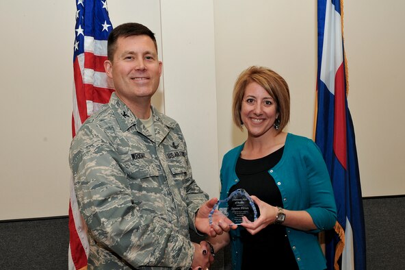 Col. Dan Wright, 460th Space Wing commander, presents the Community Heroes of Buckley Award to Suzanne Pitrusu, the 5th community member to receive this recognition May 8, 2014, at the 140th Headquarters Building on Buckley Air Force Base, Colo. The CHOB program was started in 2011 as a way to recognize community leaders for their outstanding service to Team Buckley. (U.S. Air Force photo by Senior Airman Phillip Houk/Released)