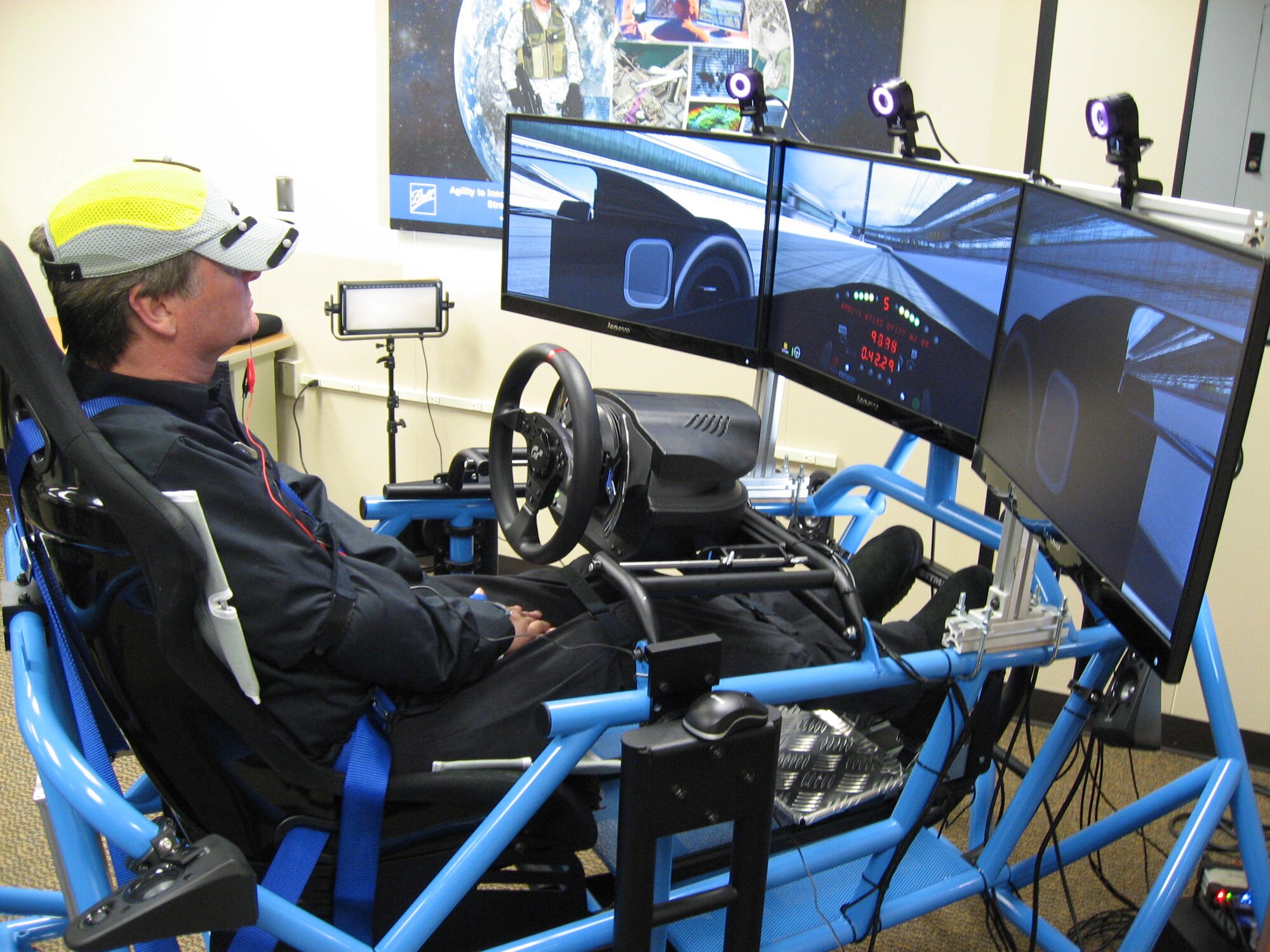 Sam Schmidt, former Indi Race Car driver sits in a car simulator driving on a simulated race tract at Indianapolis Motor Speedway.  Schmidt drives the car with human performance technologies.  During his practice section on March 20, he had the car up to 98 mph. (USAF photo by Ted Theopolos)