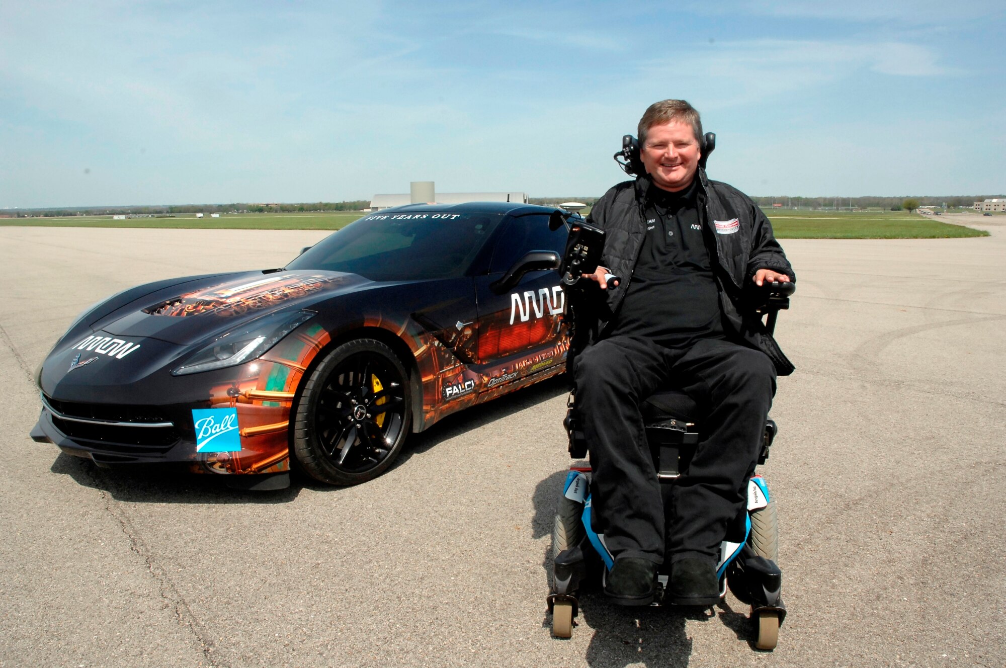 Sam Schmidt, former Indi Race Car driver is stationed in front of a Semi-Autonomous Motorcar know as SAM which he drove 84 mpr on the runway next to the National Museum of the United States Air Force during a demonstration to showcase new human performance technologies on May 6. (USAF photo by Al Bright)