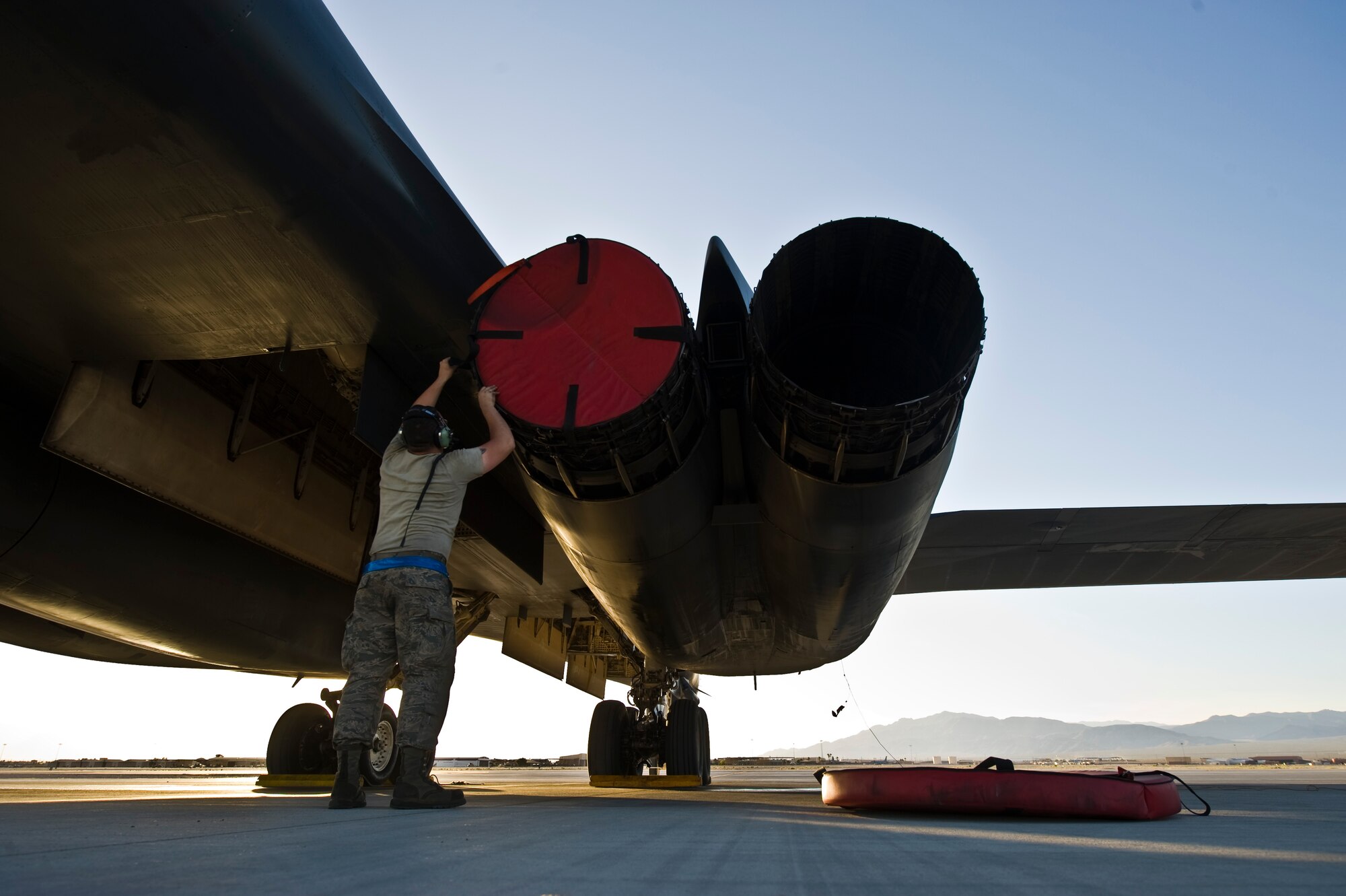 Senior Airman Andrew Lawson, 7th Aircraft Maintenance Squadron aerospace propulsion journeyman, places exhaust plugs on a B-1B Lancer assigned to the 7th Bomb Wing, Dyess Air Force Base, Texas, during Green Flag 14-6 April 24, 2014, at Nellis Air Force Base, Nev. Green Flag is a realistic air-land integration combat training exercise that involves the U.S. and its allies. (U.S. Air Force photo by Senior Airman Christopher Tam/Released)