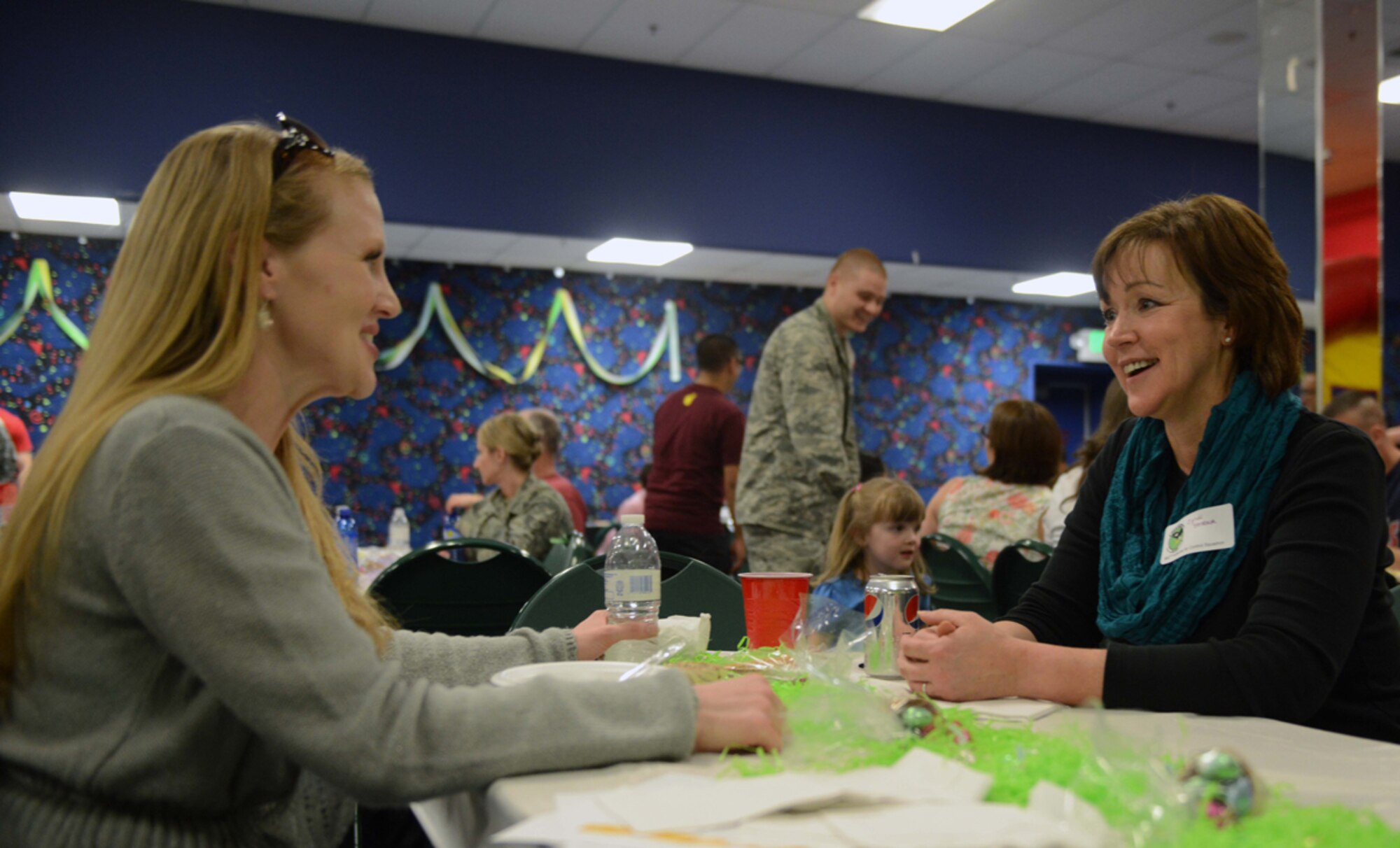 JOINT BASE ELMENDORF-RICHARDSON?Tara Lloyd, spouse of Air Force Capt. Anson Lloyd, of the 673d Medical Support Squadron, speaks with Cyndi Strobach, spouse of Air Force Lt. Col. Ron Strobach, 962nd Airborne Air Control Squadron, during the deployed spouses dinner at the Arctic Oasis on Joint Base Elmendorf-Richardson, Alaska, April 30, 2014. The dinner is a way for spouses to connect with one another and with unit personnel while their loved ones are deployed around the world. (U.S. Air Force photo/Airman 1st Class Ty-Rico Lea)