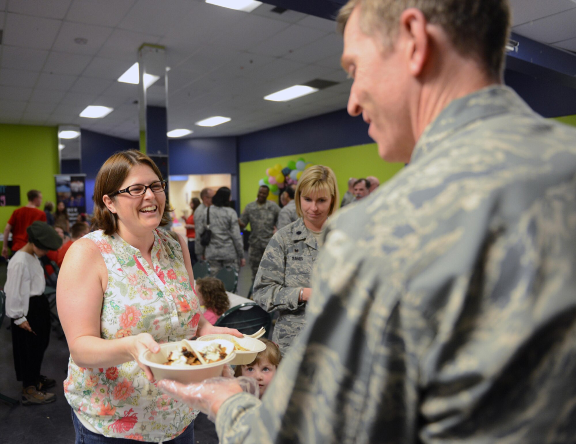 JOINT BASE ELMENDORF-RICHARDSON?Katie Bromen receives a plate of food from Air Force Chaplain (Capt.) Brian Musselman, a 673d Air Base Wing chaplain, during the deployed spouses dinner at the Arctic Oasis on Joint Base Elmendorf-Richardson, Alaska, April 30, 2014. The dinner recognizes spouses of military members currently deployed. Katie is the spouse of Air Force Lt. Col. Christopher Bromen, 673d Security Forces Squadron commander.  (U.S. Air Force photo/Airman 1st Class Ty-Rico Lea)