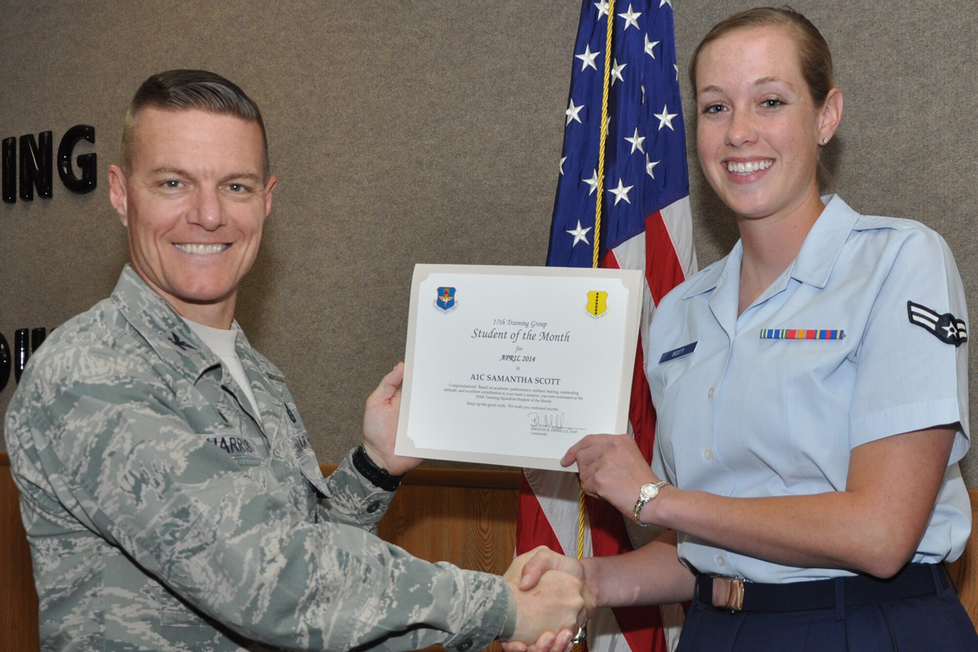 GOODFELLOW AIR FORCE BASE, Texas -- Col. Brendan M. Harris, 17th Training Group Commander, presents the 316th Training Squadron Enlisted Student of the Month award for April 2014 to Airman 1st Class Samantha S. Scott May 2. (U.S. Air Force photo/ Airman 1st Class Breonna Veal)