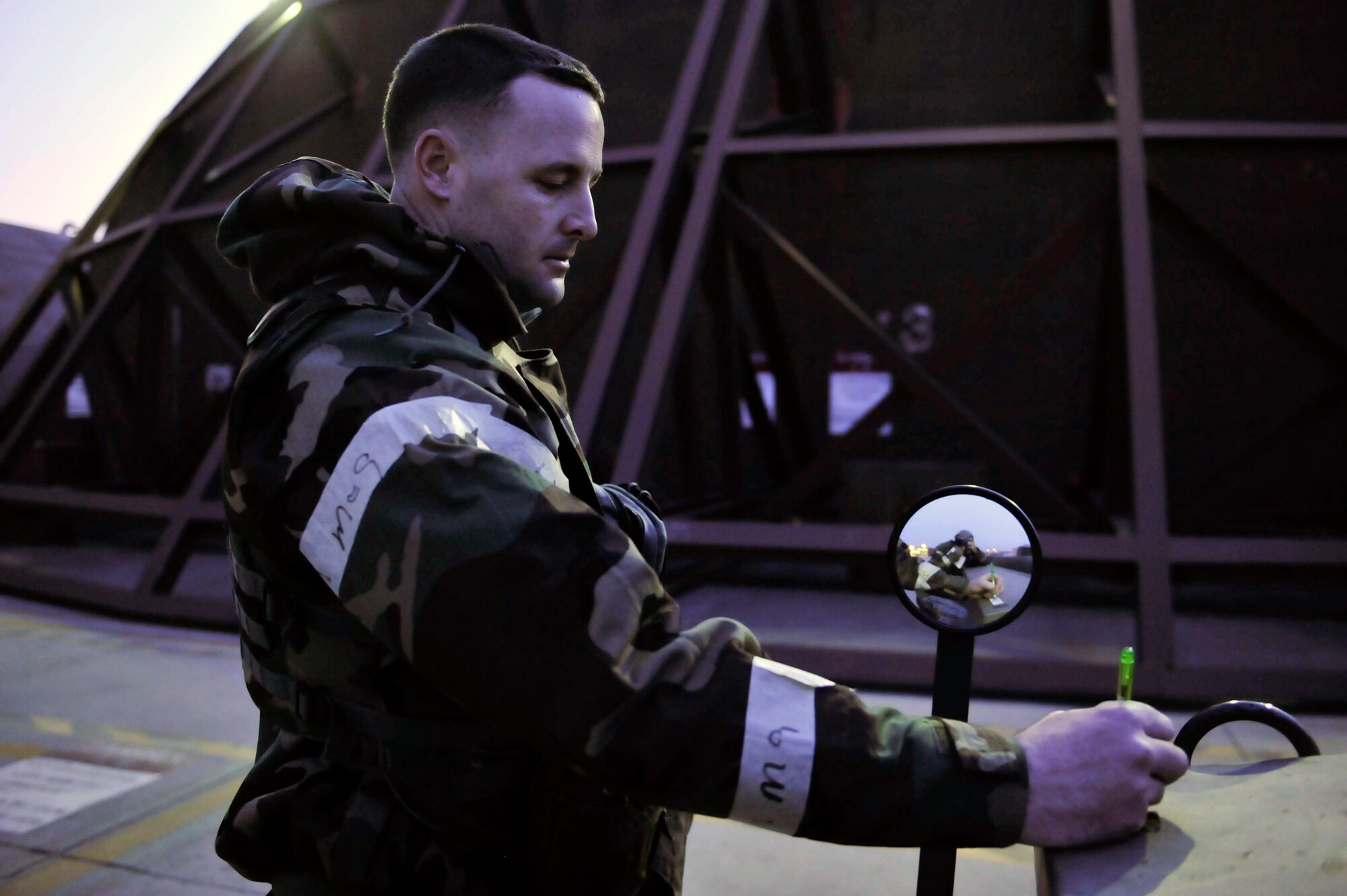 Master Sgt. Daniel Blair, 51st Fighter Wing inspections superintendent, marks M8 tape to show that the vehicle has been contaminated on the flight line at the start of the theater ballistic missile attack scenario May 8 on Osan Air Base, Republic of Korea. Some symptoms of the VX nerve agents may be muscular twitching or sweating at the area of exposure followed by vomiting. (U.S. Air Force photo by Senior Airman David Owsianka)