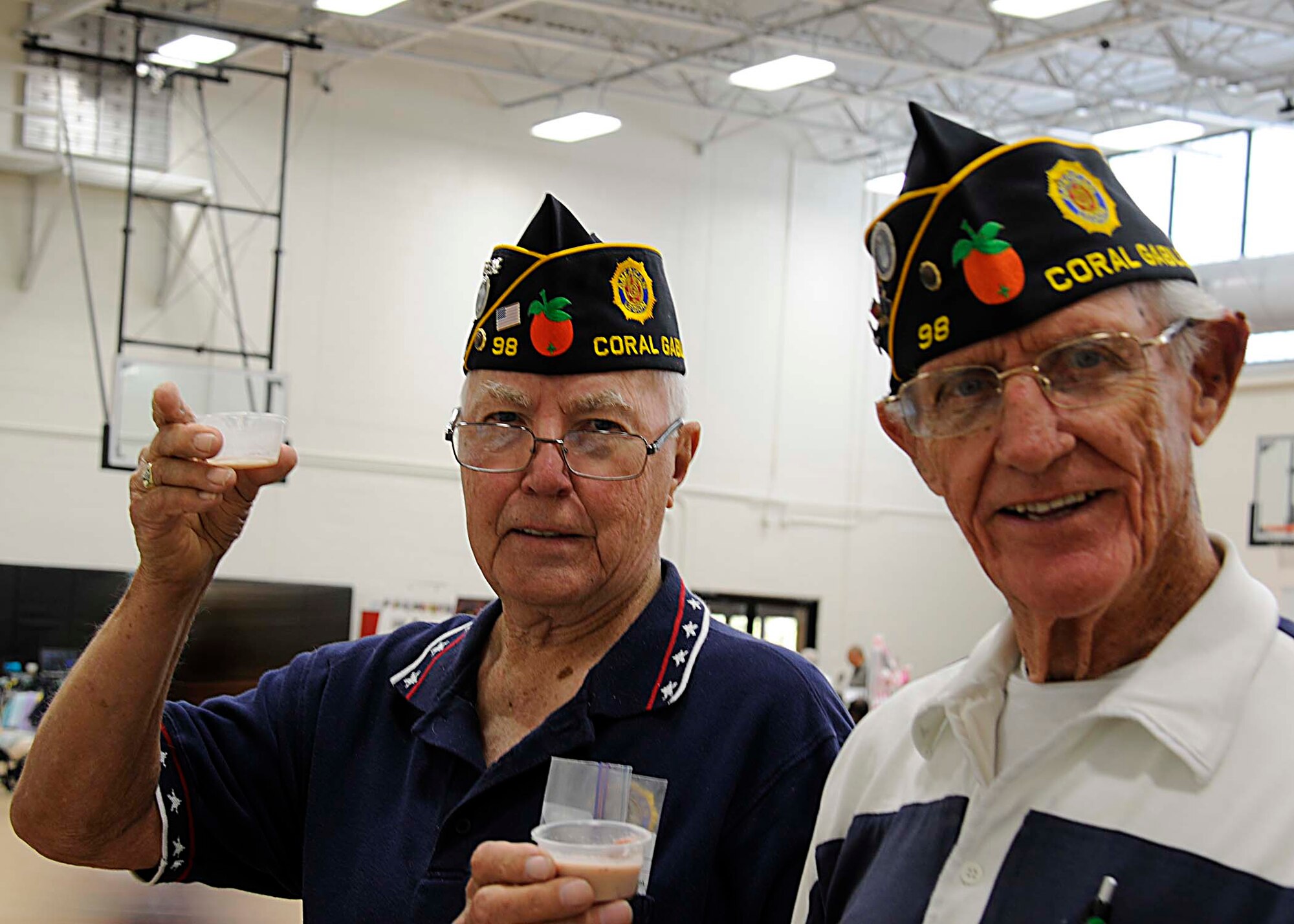 Robert Barry and Bob Hadnot sample a health drink on May 3 at the first Spring Bazaar in the Sam Johnson Fitness Center at Homestead Air Reserve Base, Fla. These veterans were on of over 40 local businesses and vendors that manned a booth at the Spring Bazaar, but posed for a photo while on a break to visit the other booths at the event. (U.S. Air Force photo by/Senior Airman Aja Heiden)
