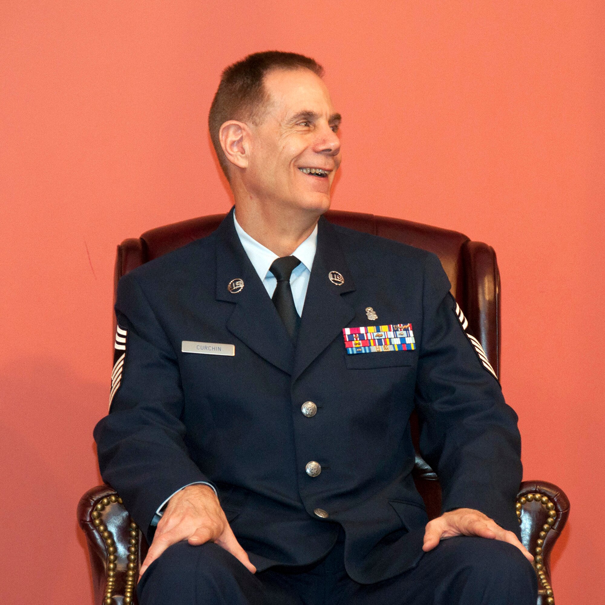 TRAVIS AIR FORCE BASE, Calif. --Chief Master Sgt. Neil Curchin, 349th Medical Squadron medical administrative manager, laughs as stories are told about his military career during a retirement ceremony April 27, 2014, at Travis Air Force Base, Calif. Curchin is retiring after 42 years of military service. (U.S. Air Force photo/Master Sgt. Rachel Martinez)