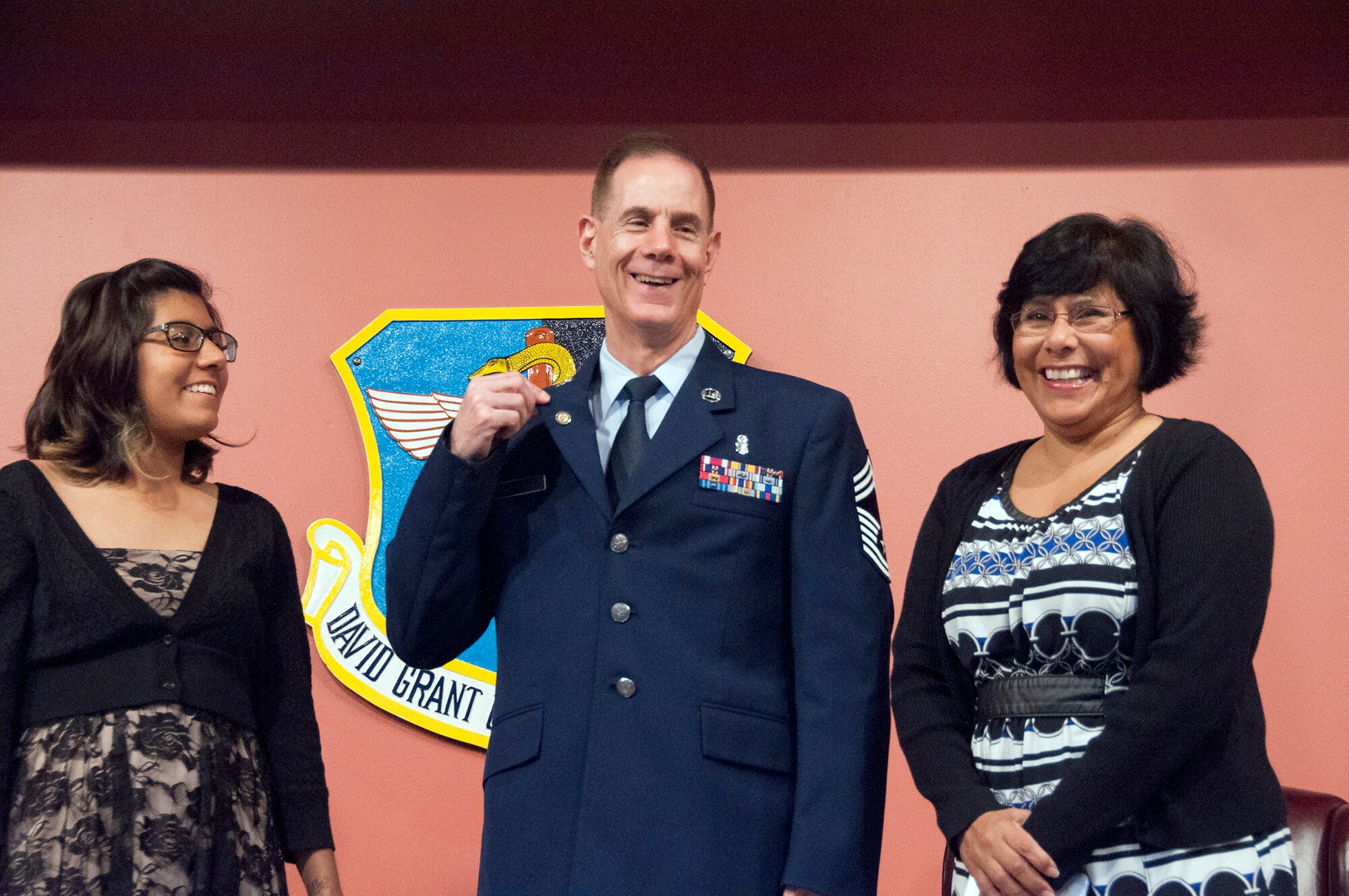 TRAVIS AIR FORCE BASE, Calif. -- Surrounded by his daughter and wife, Chief Master Sgt. Neil Curchin, 349th Medical Squadron medical administrative manager, shows off his retirement pin during a ceremony April 27, 2014, at Travis Air Force Base, Calif. Friends, family and coworkers gathered together to celebrate the chief’s four decades of military service. (U.S. Air Force photo/Master Sgt. Rachel Martinez)