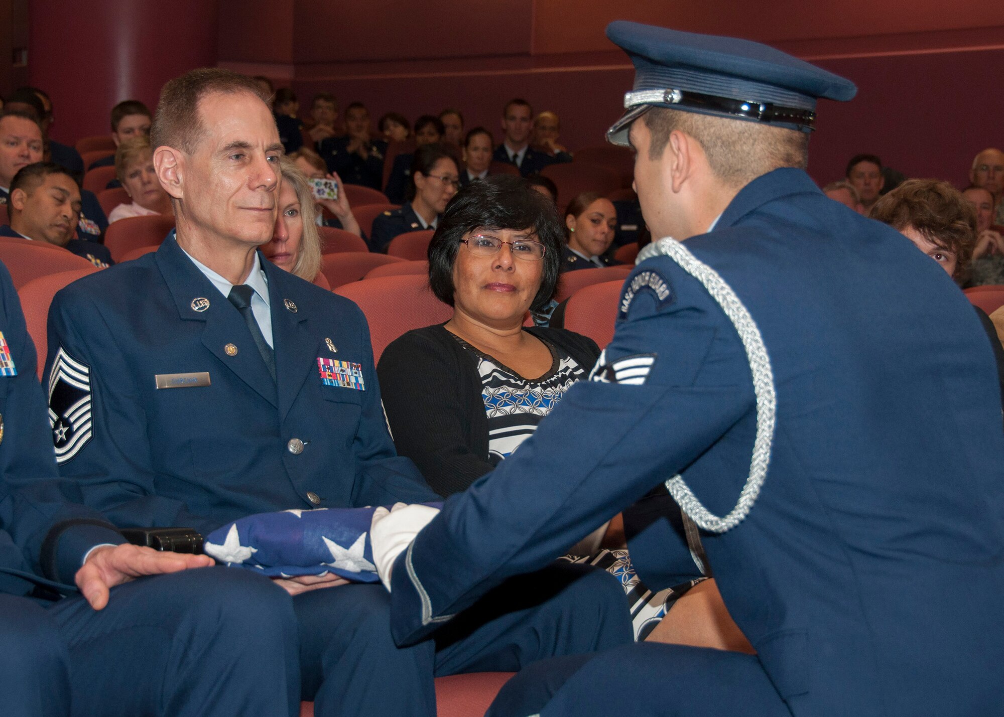 TRAVIS AIR FORCE BASE, Calif. -- Chief Master Sgt. Neil Curchin, 349th Medical Squadron medical administrative manager, is presented a U.S. flag by a member of the honor guard on the occasion of his retirement April 27, 2014, at Travis Air Force Base, Calif. After more than 40 years of military service, Curchin plans to continue serving the 349 MDS in a civilian capacity. (U.S. Air Force photo/Master Sgt. Rachel Martinez)