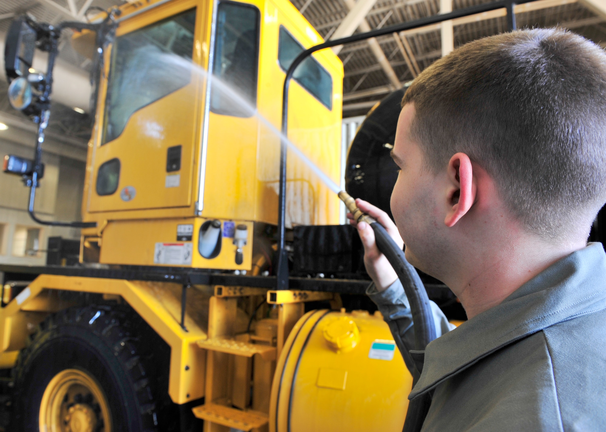Airman 1st Class Michael Pitts, 354th Civil Engineer Squadron heavy equipment operator, washes the outside of a snow plow April 28, 2014, Eielson Air Force Base, Alaska. Over 35 pieces of snow removal equipment will be washed to turn in to the 354th Logistics Readiness Squadron for maintenance. (U.S. Air Force photo by Senior Airman Ashley Nicole Taylor/Released)