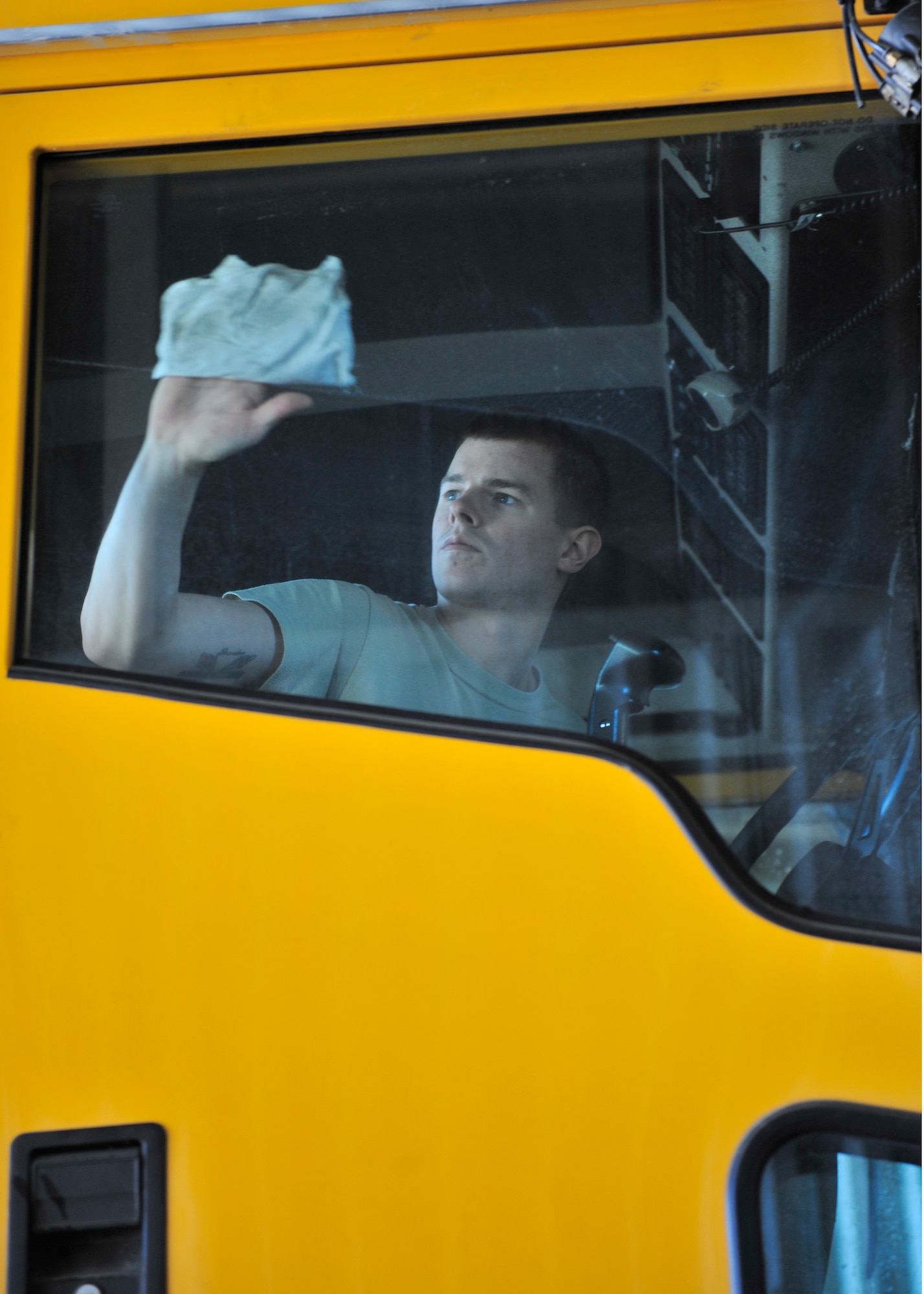 Airman 1st Class Steven Hansen, 354th Civil Engineer Squadron heavy equipment operator, washes the inside window of a snow plow April 28, 2014, Eielson Air Force Base, Alaska. Hansen and a team of two other Airmen will clean 35 pieces of snow equipment to turn in to the 354th Logistics Readiness Squadron for maintenance during the summer. (U.S. Air Force photo by Senior Airman Ashley Nicole Taylor/Released)