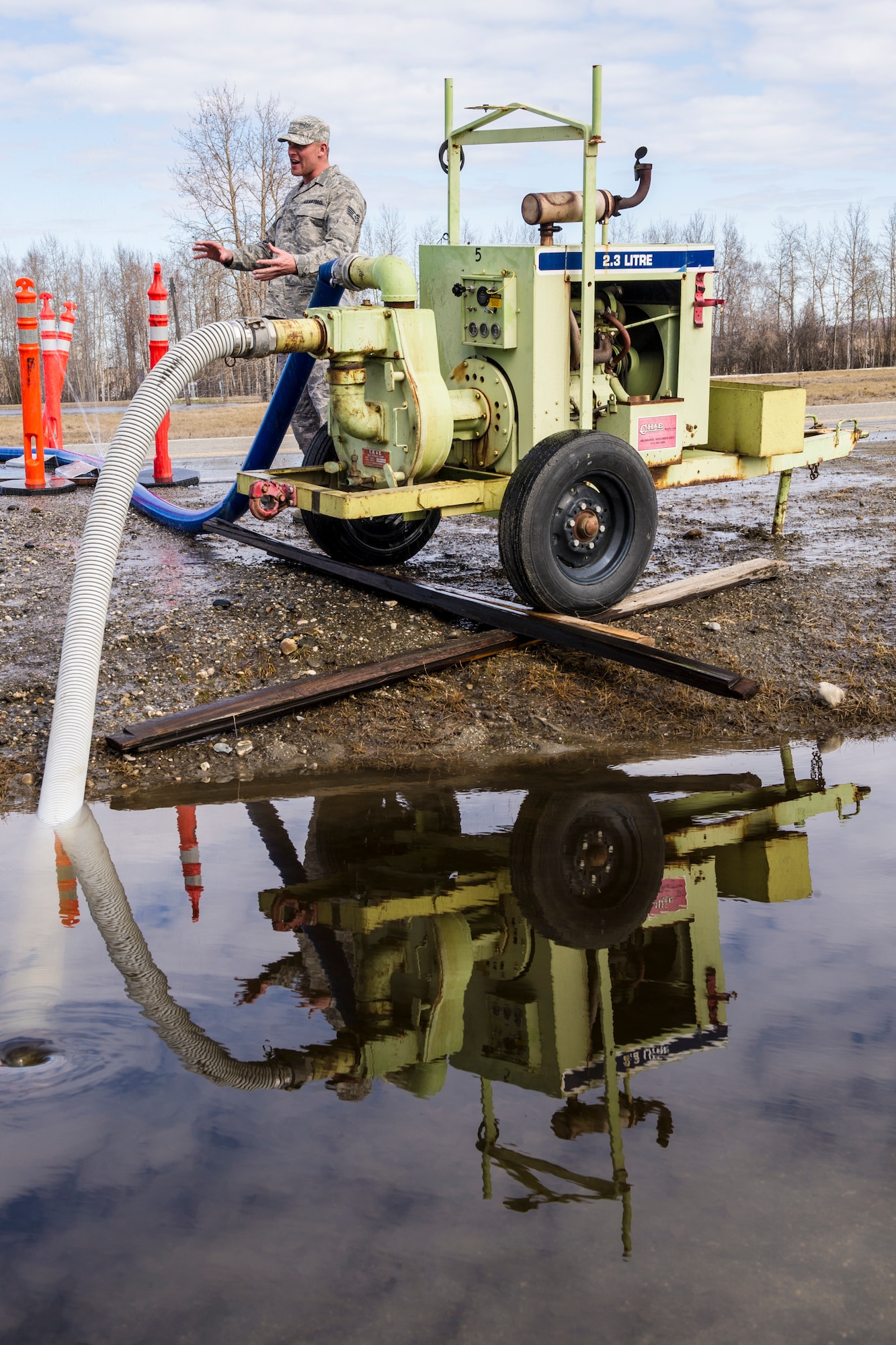 Staff Sgt. Ryan Halter, 354th Civil Engineer Squadron pavements and construction journeyman, sets up a water pump April 22, 2014, Eielson Air Force Base, Alaska. The Dirt Boyz kept melting snow from entering six facilities preventing potential water damage. (U.S. Air Force photo by Senior Airman Joshua Turner/Released)