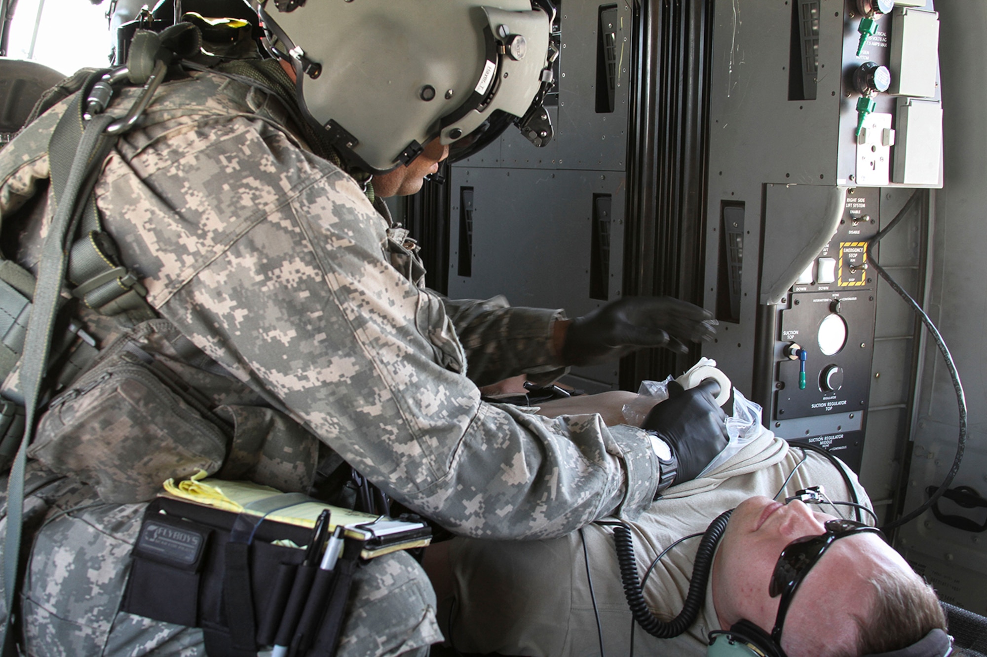 Spc. T.J. Hayer, a medical technician assigned to the 7th Battalion, 158th Aviation Regiment of the Army National Guard, provides simulated medical attention to Sgt. Ryan Swain’s sucking chest wound during a simulated casualty evacuation scenario as part of Exercise ANGEL THUNDER at Davis-Monthan AFB, Ariz., May 7, 2014.  ANGEL THUNDER is a multilateral annual exercise that to supports DoD’s training requirements for Personnel Recovery responsibilities through high–fidelity exercises.  Exercise ANGEL THUNDER focuses on scenarios that rescue forces are likely to face in current and future contingencies—increasing their combat readiness across a range of military options. (U.S. Air Force photo by Tech. Sgt. Heather R. Redman/Released)