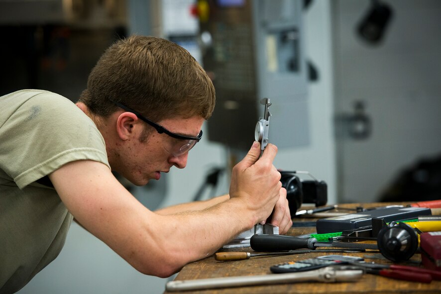 U.S. Air Force Senior Airmen Mark Jensen, 23d Equipment Maintenance Squadron aircraft metals technology journeyman, measures a fitting used on aircraft crew doors at Moody Air Force Base, Ga., April 30, 2014. Each part requires strict, precise measurements to be used on an aircraft. (U.S. Air Force photo by Airman 1st Class Ryan Callaghan/Released)