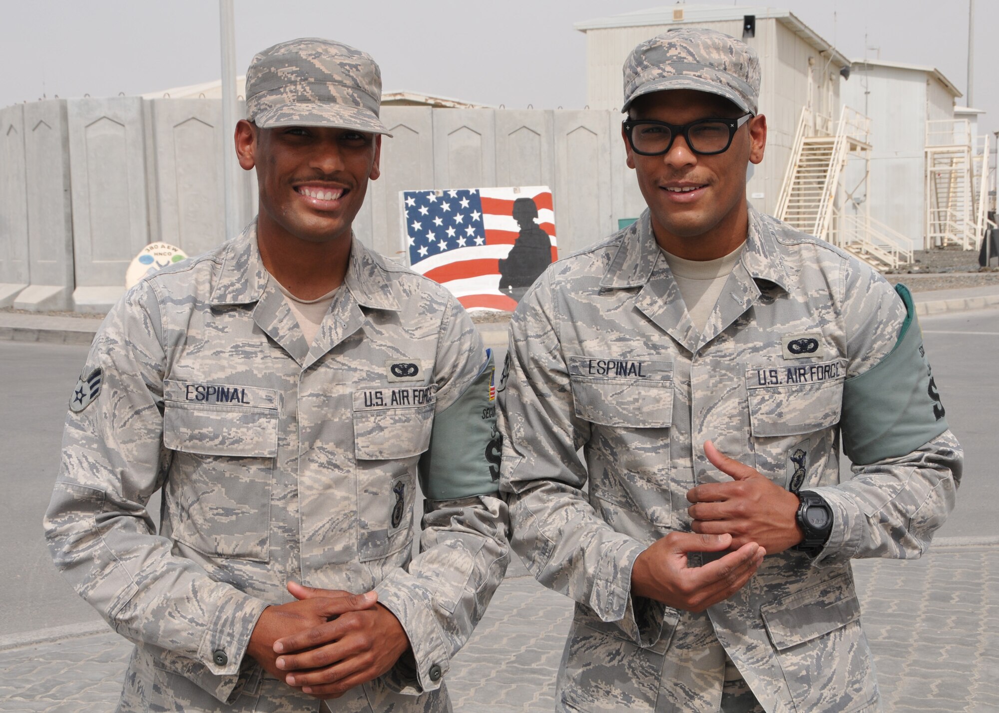 (Left to right) Air Force Senior Airman Edward Espinal and Senior Airman Edwin Espinal meet up during a shift change for the 380th Expeditionary Security Forces Squadron at an undisclosed location in Southwest Asia on May 1, 2014. The identical twins are security forces specialists and are deployed from the 113th Wing of the D.C. Air National Guard. (U.S. Air Force photo by Senior Master Sgt. Eric Peterson/Released)