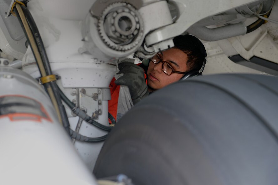U.S. Air Force Senior Airman Nestor Fraga, 726th Air Mobility Squadron crew chief from Crossville, Tenn., wipes down main landing gear during a post-flight inspection of a U.S. Air Force C-17 Globemaster III Cargo Aircraft at Spangdahlem Air Base, Germany, May 7, 2014. Upon recovering an aircraft, Airmen from the 726th coordinate with flight crew to prepare for its next departure. (U.S. Air Force photo by Senior Airman Alexis Siekert/Released)