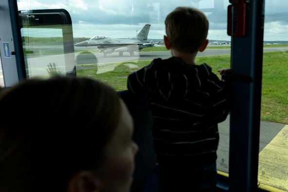 A military spouse and children watch a U.S. Air Force F-16 Fighting Falcon fighter aircraft taxi on the flightline during a 52nd Maintenance Group spouse’s tour May 7, 2014, at Spangdahlem Air Base, Germany. During the tour, military families saw the process of launching aircraft. (U.S. Air Force photo by Senior Airman Rusty Frank/Released)
