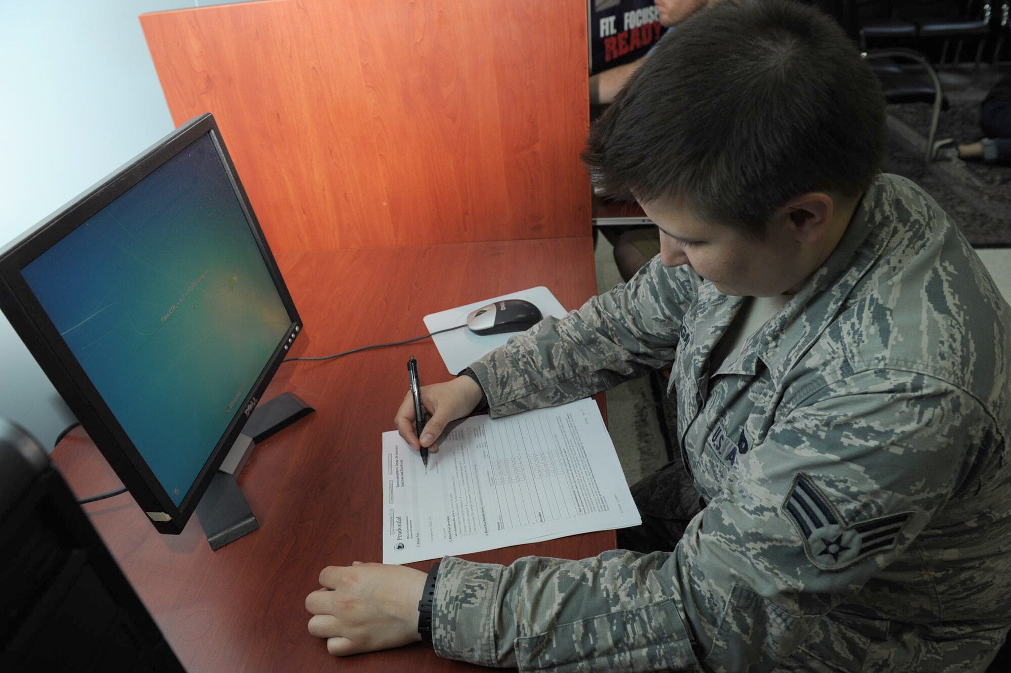 Senior Airman Meagan Hillengas, 39th Security Forces Squadron unit orientation instructor, fills out a Servicemember's Group Life Insurance form at the military personnel section May 8, 2014, Incirlik Air Base, Turkey. SGLI rates were recently raised for all service members.