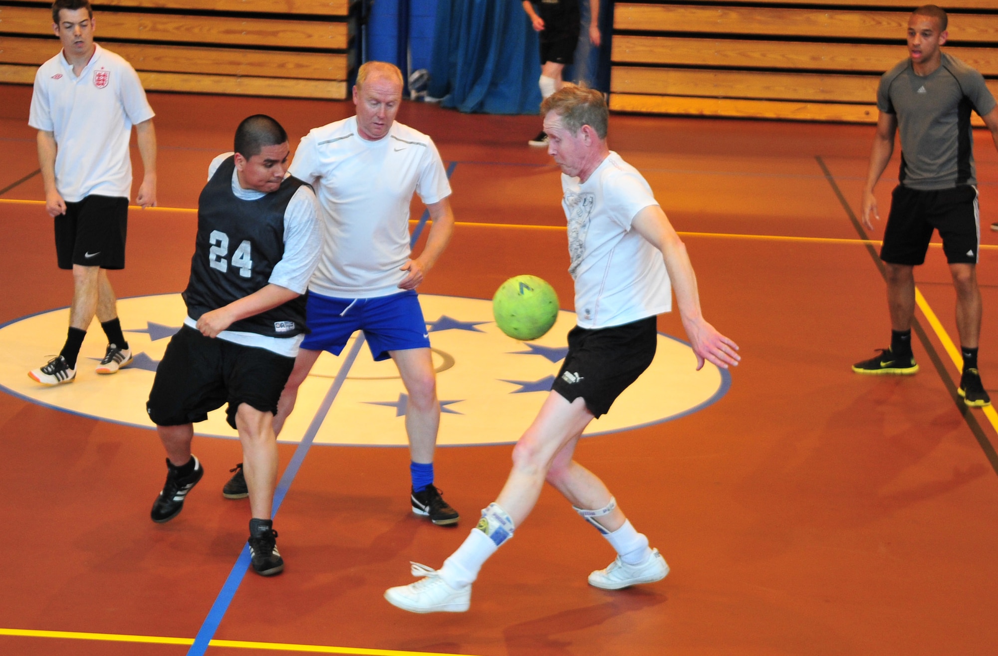Members of the 100th Civil Engineer Squadron and the 100th Force Support Squadron indoor soccer teams battle for dominance May 6, 2014, during an indoor soccer championship on RAF Mildenhall, England. The 100th CES team won 8-6. (U.S. Air Force photo by Staff Sgt. Krystie Martinez/Released)