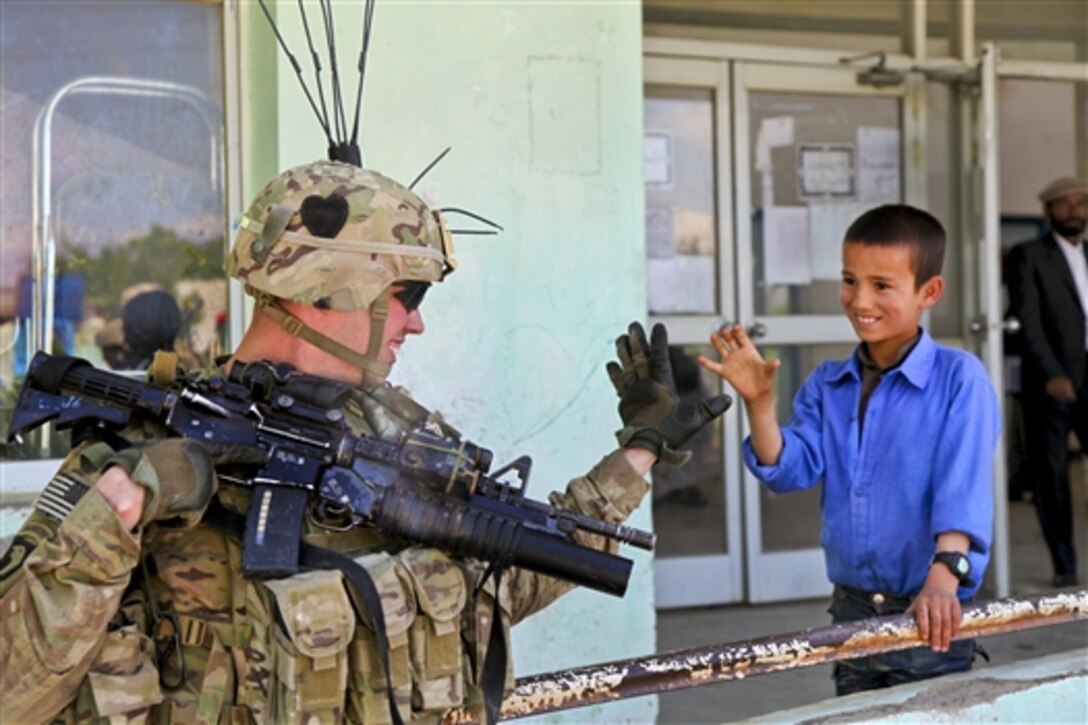 A U.S. soldier plays with an Afghan student outside a high school in Afghanistan's Parwan province, April 23, 2014. The soldiers are assigned to the 101st Airborne Division's 2nd Battalion, 502nd Infantry Regiment, and are conducting a humanitarian aid event with Afghan soldiers to provide the school's children with supplies, clothes and shoes. 