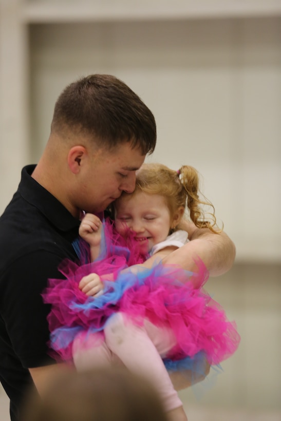 Sgt. Timothy Macleod hugs his daughter Jennalee at Marine Corps Air Station Cherry Point, N.C., after returning from a six month unit deployment program, with Marine Attack Squadron 223, in support of the 31st Marine Expeditionary Unit in Okinawa, Japan. During the UDP, VMA-223 was tasked with conducting aircraft maintenance and flight operations. Macleod is a fixed-wing aircraft safety equipment mechanic with the squadron.