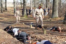 Drill Instructor Staff Sgt. Cody Romriell motivates poolees as they crawl through part of the obstacle course during the RS Twin Cities 2014 Mini-Bootcamp. More than 600 young men and women participated in the event. 