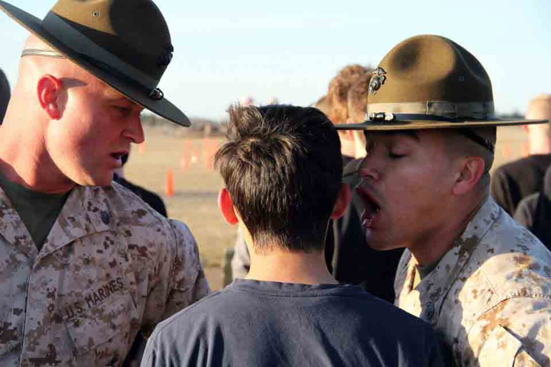 Drill Instructors Staff Sgt. Cody Romriell and Staff Sgt. Vincent Aguilar team up to yell at a poolee at the RS Twin Cities 2014 Mini-Bootcamp. Despite their intimidating nature, the drill instructors were most poolees' favorite part of the event. 