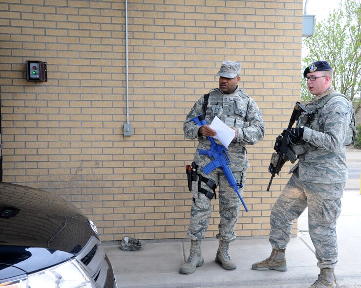 Chief Master Sgt. Phillip L. Easton, 341st Missile Wing command chief (left), and Airman Michael Sovik, 341st Security Forces Squadron installation entry controller, look over a vehicle to assure proper registration at the front gate May 6. Sovik trained Easton on the proper way to scan IDs and grant access to people trying to enter the base. (U.S. Air Force photo / Airman 1st Class Joshua Smoot)