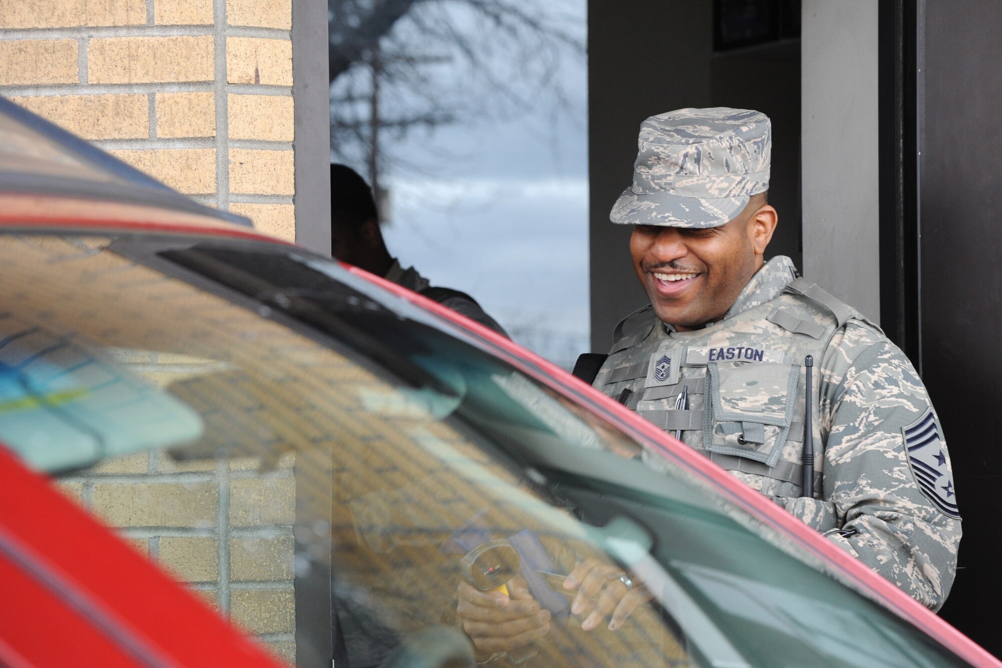 Chief Master Sgt. Phillip L. Easton, 341st Missile Wing command chief, greets and scans IDs of individuals trying to access the base May 6. Easton performed the jobs of installation entry controllers as part of a new program he is involved in where he goes out and performs Airmen’s jobs for an hour or two. (U.S. Air Force photo / Airman 1st Class Joshua Smoot)