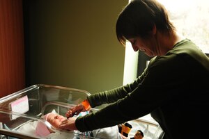 Ginger Preston (left) mother-in-law to Airman 1st Class Samuel DeWitt (right), shares a moment with her first granddaughter Kynnedie at MedStar Southern Maryland Hospital, on March 31,2014. DeWitt, 79th Medical Staging Squadron diet therapy apprentice, and his wife Kaila said Preston is their hero. (U.S. Air Force photo / Amber J. Russell)