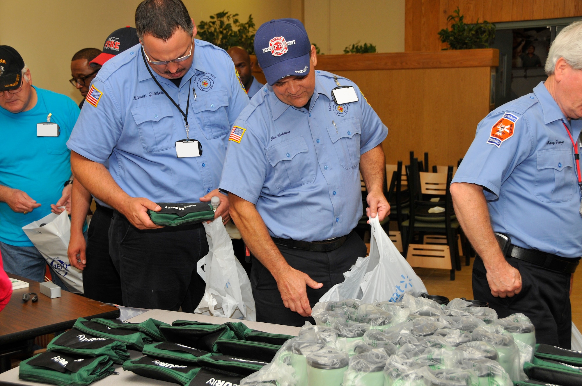 After the presentation, those who attended the AEDC Security Fair had the opportunity to receive some mementos made available by the Industrial Security Office. Marvin Greeson (left) and Jay Baldwin (right) with the Arnold Fire Department look through some items. (Photo by Jacqueline Cowan)