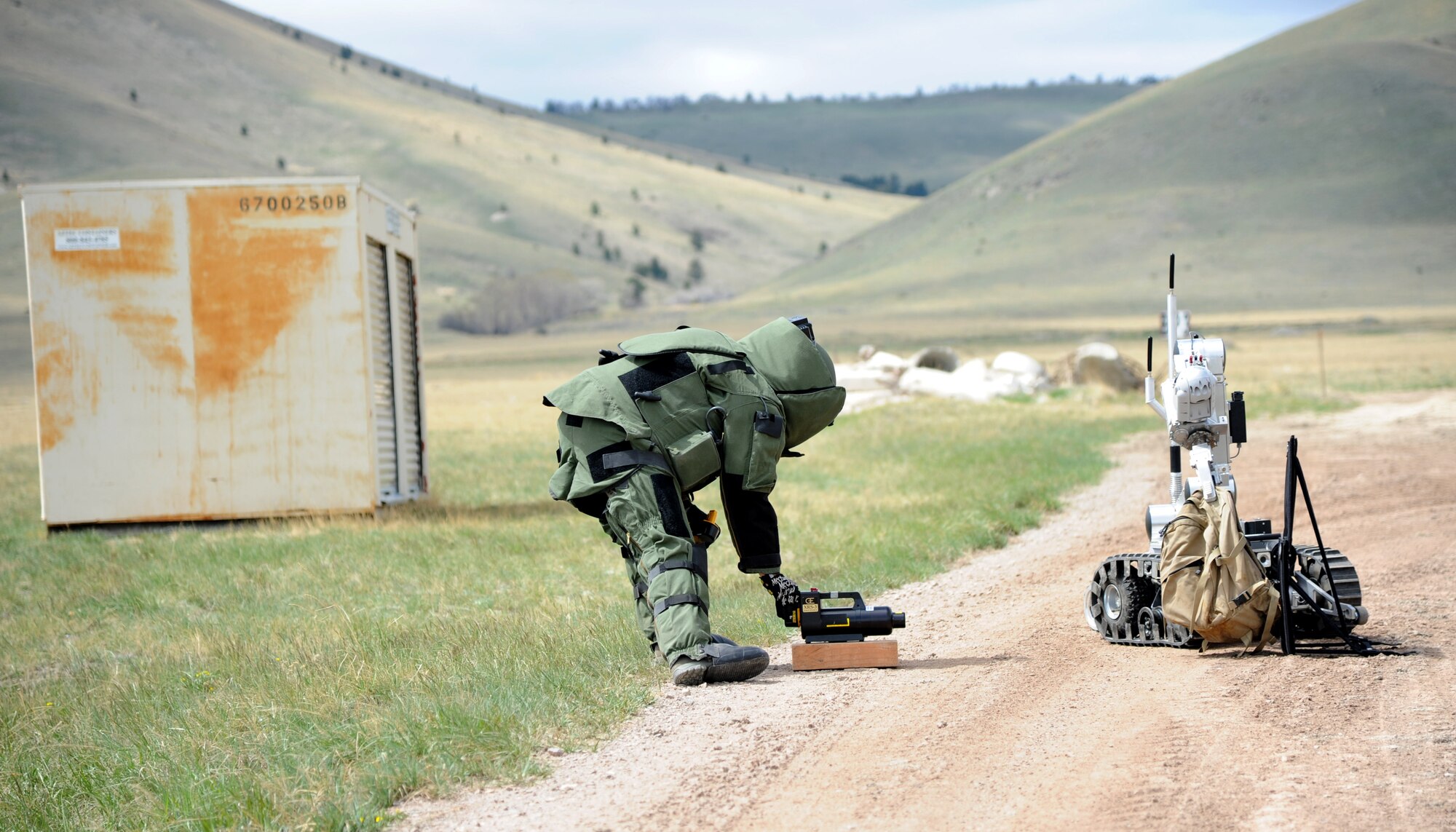 Tech Sgt. Scott Lawson, 120th Airlift Wing Explosive Ordinance Disposal technician, prepares to x-ray a backpack to verify its content while an Air Force Medium-Sized Robot holds the backpack.  During a training exercise, EOD technicians practiced on examples of overseas and stateside improvised explosive devices. (U.S. Air Force photo/ Airman 1st Class Joshua Smoot)