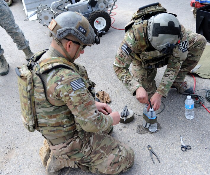 Airman 1st Class Lance Pares and Senior Airman Randy Shandler, 341st Civil Engineer Squadron Explosive Ordnance Disposal technicians, prepare an explosive water bottle charge to defeat an improvised explosive device.  During training exercises, young Airmen receive hands on training to better learn the effects of the charges they create. (U.S. Air Force photo/ Airman 1st Class Joshua Smoot)