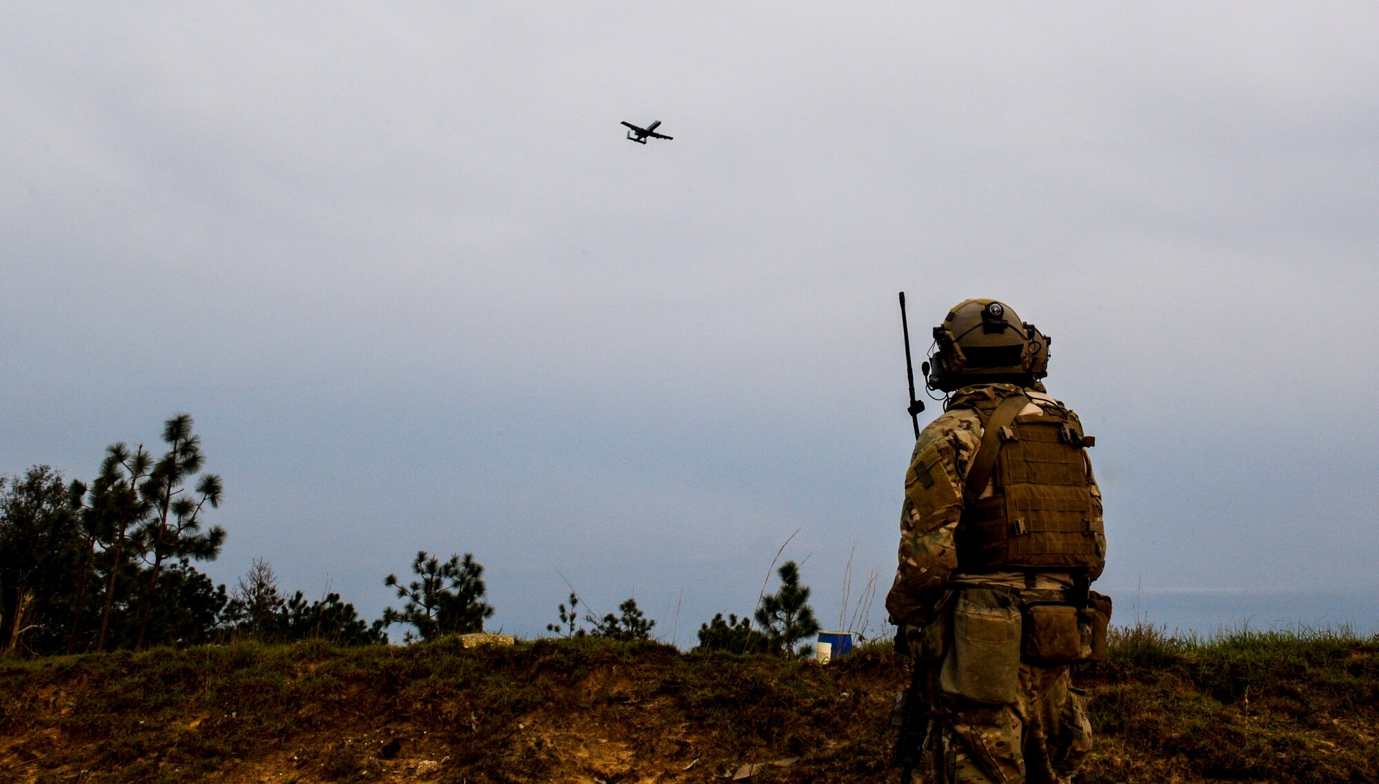 A U.S. Air Force Tactical Air Control Party member observes as an A-10 Thunderbolt II aircraft flies overhead during a close air support mission while participating in Emerald Warrior 14 at Hurlburt Field, Fla., May 1, 2014. Emerald Warrior is a U.S. Special Operations Command-sponsored two-week joint/combined tactical exercise designed to provide realistic military training in an urban setting. (U.S. Air Force photo by Senior Airman Colville McFee)