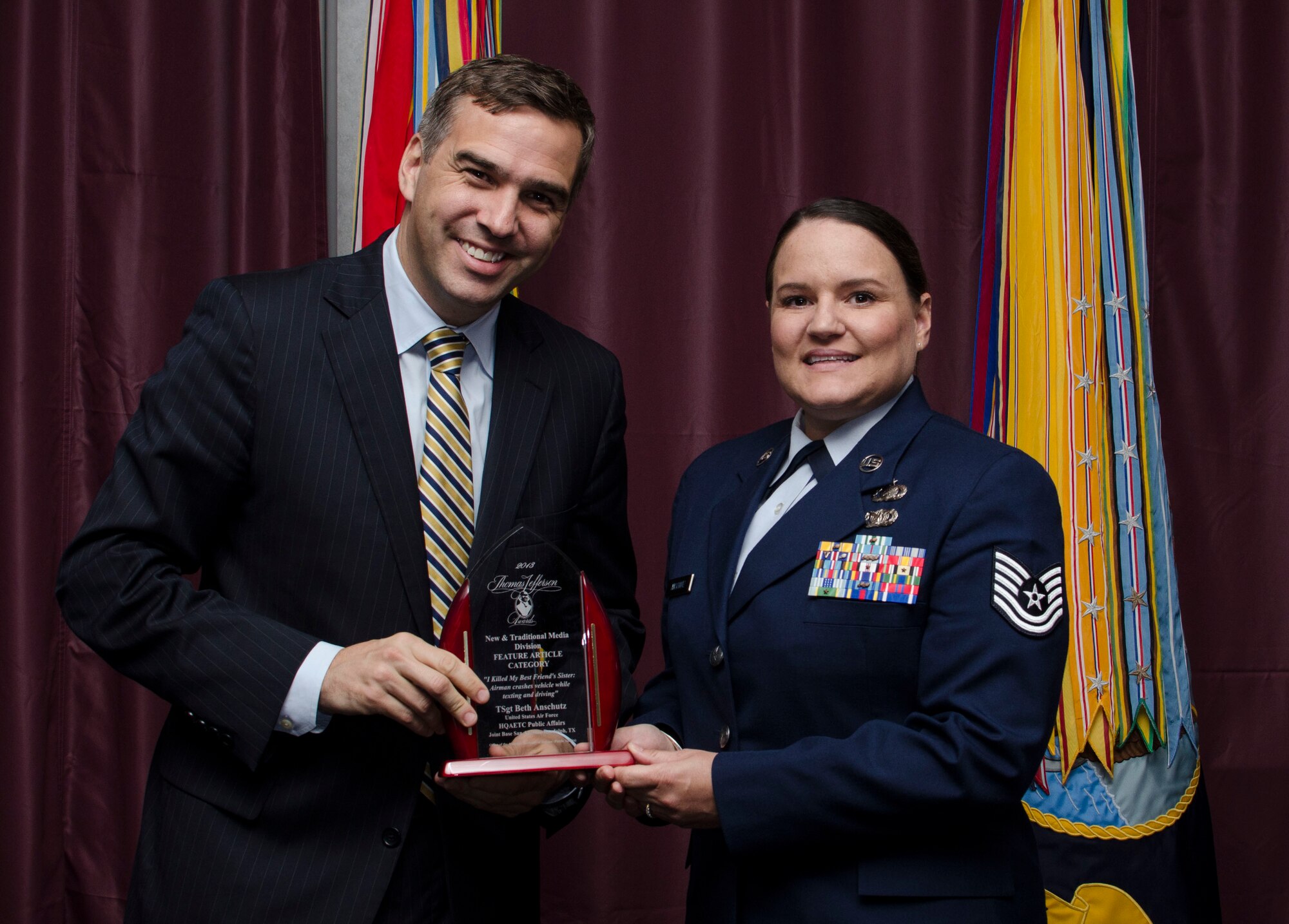 Tech. Sgt. Beth Anschutz, AETC Public Affairs at Joint Base San Antonio-Randolph, Texas, receives the Thomas Jefferson Award (feature category) from Brent Colburn, Assistant to the Secretary of Defense for Public Affairs, during an award ceremony at the Defense Information School, Fort George G. Meade, Maryland May 9, 2014. Anschutz won for her gripping tale about the consequences of texting and driving.. (Courtesy photo) 
