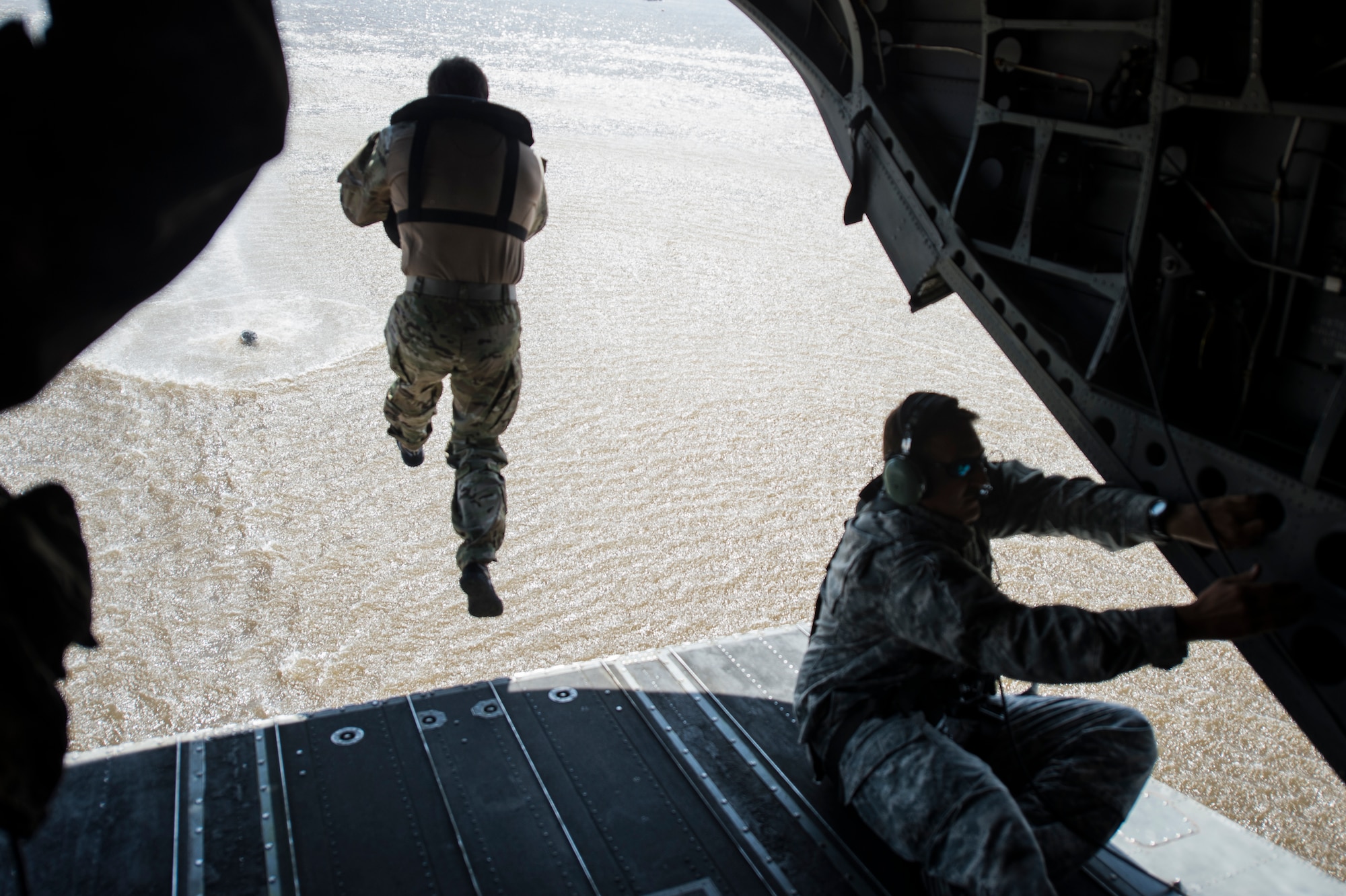 A U.S. Soldier with the 20th Special Forces Group jumps from a CH-47 Chinook helicopter for helocast training, an airborne technique used by small forces to insert into a military area of operations, during Emerald Warrior 14 in Gulfport, Miss., April 30, 2014. Emerald Warrior is a U.S. Special Operations Command-sponsored two-week joint/combined tactical exercise designed to provide realistic military training in an urban setting. (U.S. Air Force photo by Senior Airman Jodi Martinez)