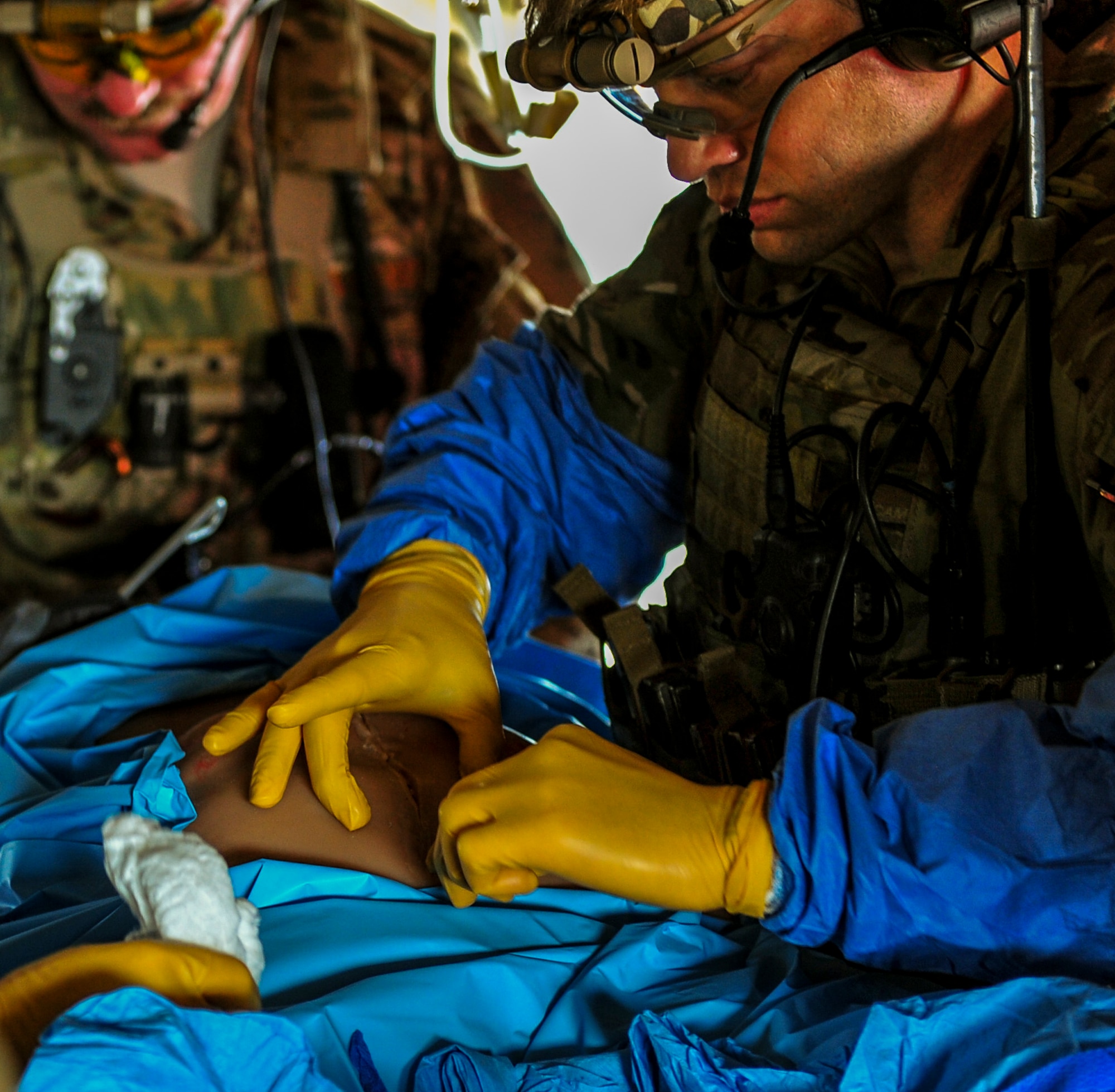 A U.S. Air Force combat medic treats a simulated wound in an Army CH-47 Chinook helicopter during Emerald Warrior 14 at Hurlburt Field, Fla., May 3, 2014. Emerald Warrior is a U.S. Special Operations Command-sponsored two-week joint/combined tactical exercise designed to provide realistic military training in an urban setting. (U.S. Air Force photo by Senior Airman Colville McFee)