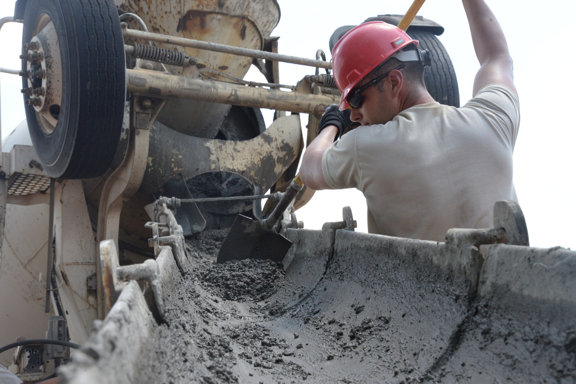 U.S. Air Force Staff Sgt. Corey Griffin, 823rd Rapid Engineer Deployable Heavy Operational Repair Squadron Engineers heavy equipment operator, assigned to Hurlburt Field, Fla., scoops wet cement from a cement truck at Shaw Air Force Base, S.C., May 8, 2014. Griffin and the other RED HORSE Airmen are completing a troop project at Shaw AFB to widen Patrol Road from 20 to 24 feet, and expansion which will meet current South Carolina Department of Transportation requirements. (U.S. Air Force photo by Airman 1st Class Michael A. Cossaboom/Released)