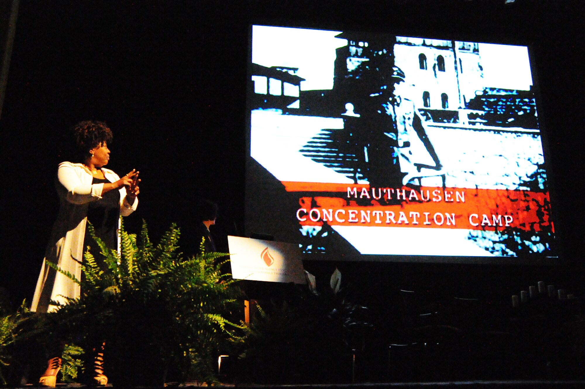 Air Force District of Washington Commander Maj. Gen. Sharon K. G. Dunbar and a sign language interpreter watch a video of a survivor's experience during the Federal Inter-Agency Holocaust Remembrance Program "Eyewitness To Evil" at the Lincoln Theater in Washington D.C., May 7, 2014. The program invited Maj. Gen. Dunbar as a keynote speaker as well as survivors of the Holocaust and Bosnian War to share their stories. (U.S. Air Force photo/Staff Sgt. Matt Davis)