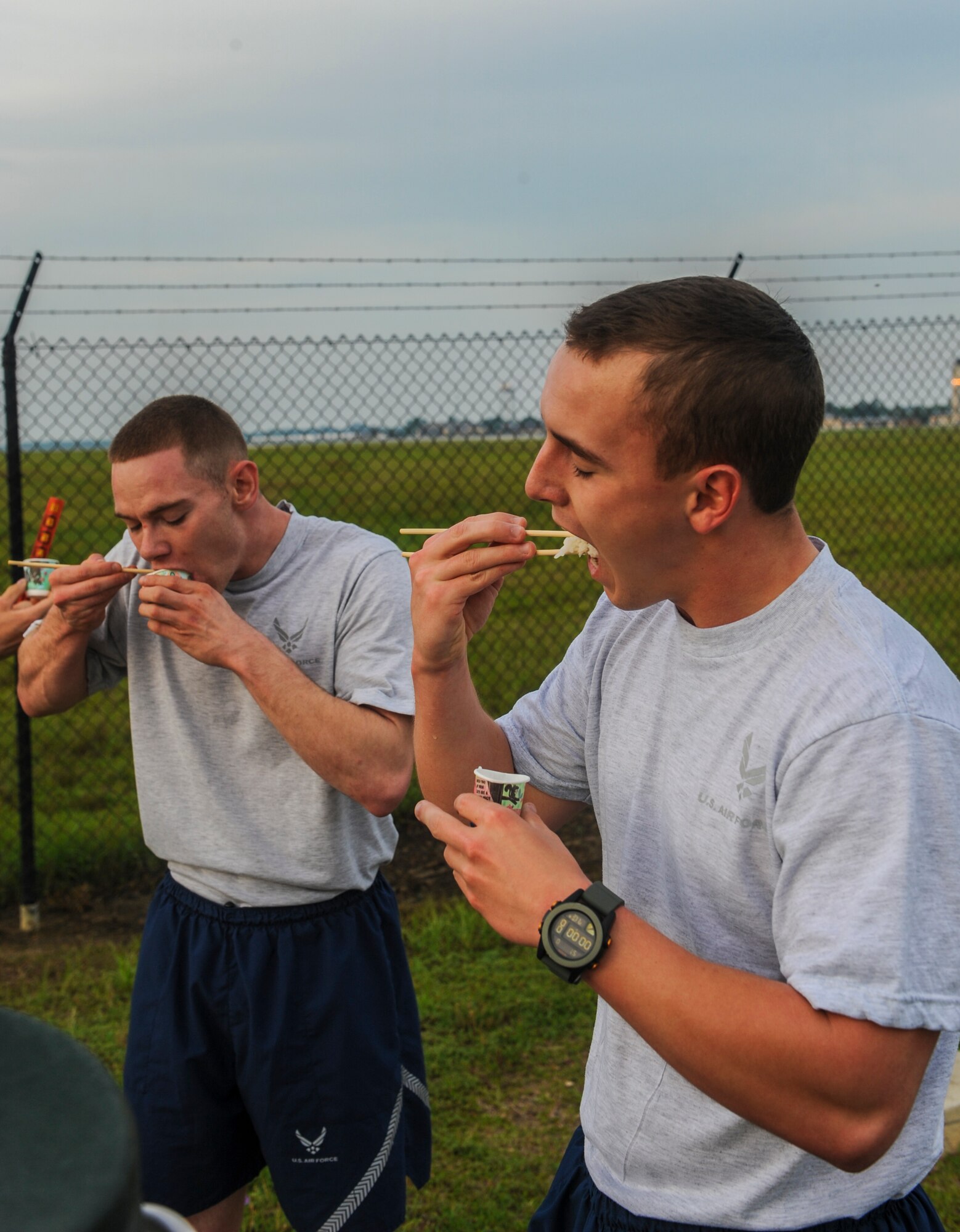 Airmen participating in a 5k are tasked with eating rice with chopsticks at Moody Air Force Base, Ga., May 9, 2014. The rice table was set up halfway through the run which incorporated a small part of Asian American/Pacific Islander Heritage. (U.S. Air Force photo by Airman 1st Class Alexis Millican/Released)