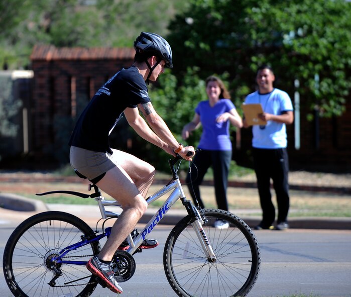 U.S. Air Force Airman 1st Class David Brunz, 317th Maintenance Squadron, competes in the Dyess Triathlon May 3, 2014, at Dyess Air Force Base, Texas. The 12.3-mile bike route circled the base twice. During National Physical Fitness Month, the Dyess Fitness Center encourages Team Dyess to take walks and bike rides with family or friends in the evenings when it’s not too hot. (U.S. Air Force photo by Airman 1st Class Kedesha Pennant/Released)