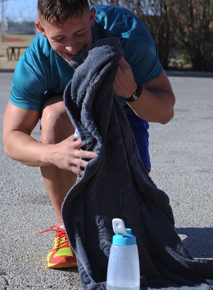 U.S. Air Force Airman 1st Class Andrew Ironstone, 317th Aircraft Maintenance Squadron, prepares for the cycling segment of the Dyess Triathlon after swimming 425 meters May 3, 2014, at Dyess Air Force Base, Texas. Participants biked 12.3 miles before finishing the race with a 3.4 mile run. (U.S. Air Force photo by Airman 1st Class Kedesha Pennant/Released)