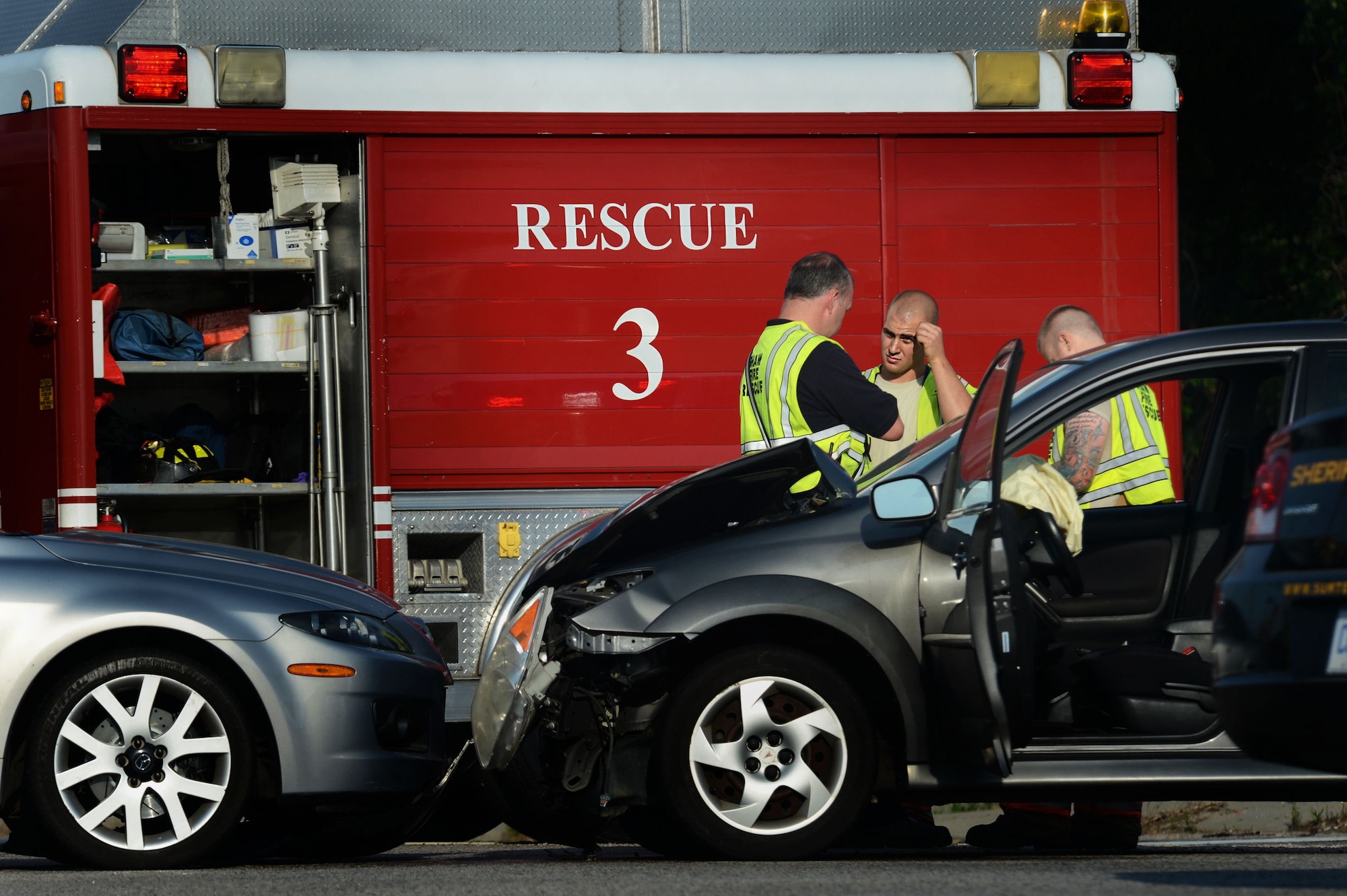 [From left] Greg Farley, 20th Civil Engineer Squadron fire captain, Airman 1st Class Clayton Angeloff and Staff Sgt. Darin Meek, 20th CES firefighters, respond to a vehicle accident on U.S. Route 378, in Sumter, S.C., May 9, 2014. The three responded to the accident at approximately 8:00 a.m., after the two vehicles collided on the road just outside of Shaw Air Force Base. (U.S. Air Force photo by Airman 1st Class Jensen Stidham/Released)