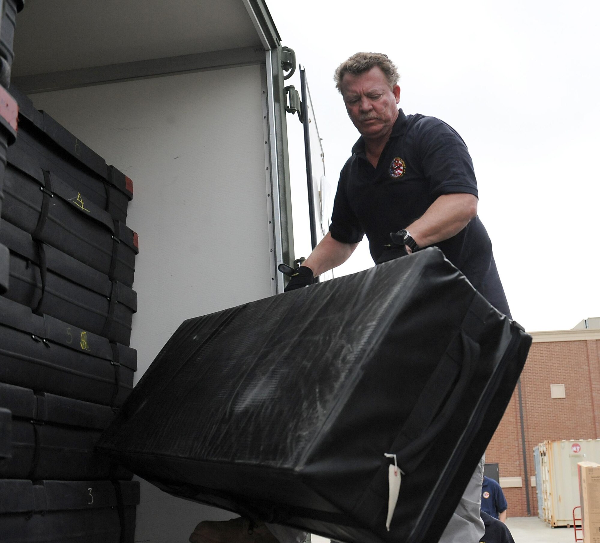 Tony Kelly, deputy current operations chief, Joint Task Force Civil Support, unloads equipment from a container during an Early Entry Command Post deployment exercise at Fort Eustis, Va., May 8, 2014. JTF-CS is preparing for Sudden Response 2014 which will test the unit's movement of equipment and personnel during the initial phases of a simulated man-made or natural disaster. JTF-CS anticipates, plans and prepares for chemical, biological, radiological and nuclear defense support to civil authorities response operations. (Official DOD photo by U.S. Navy Petty Officer 1st Class Brian Dietrick))
