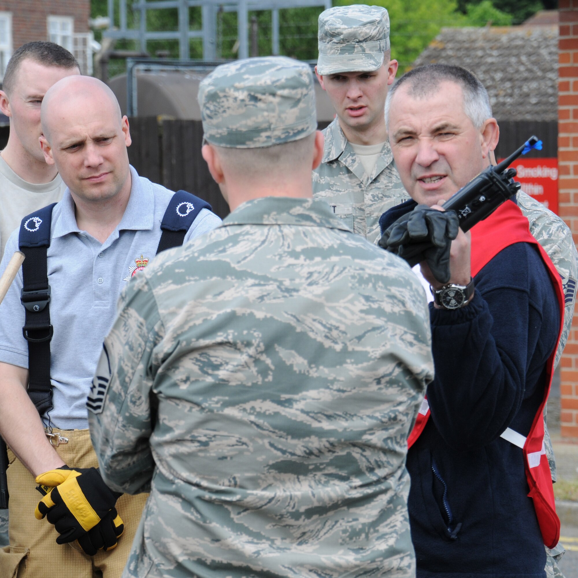 David Bootman, right, 100th Civil Engineer Squadron Fire Department watch manager from Lakenheath, Suffolk, debriefs a group of firefighters and emergency managers following a hazardous materials exercise May 6, 2014, on RAF Mildenhall, England. The base exercises regularly to ensure emergency responders remain proficient for any real-world incidents. (U.S. Air Force photo by Gina Randall/Released)