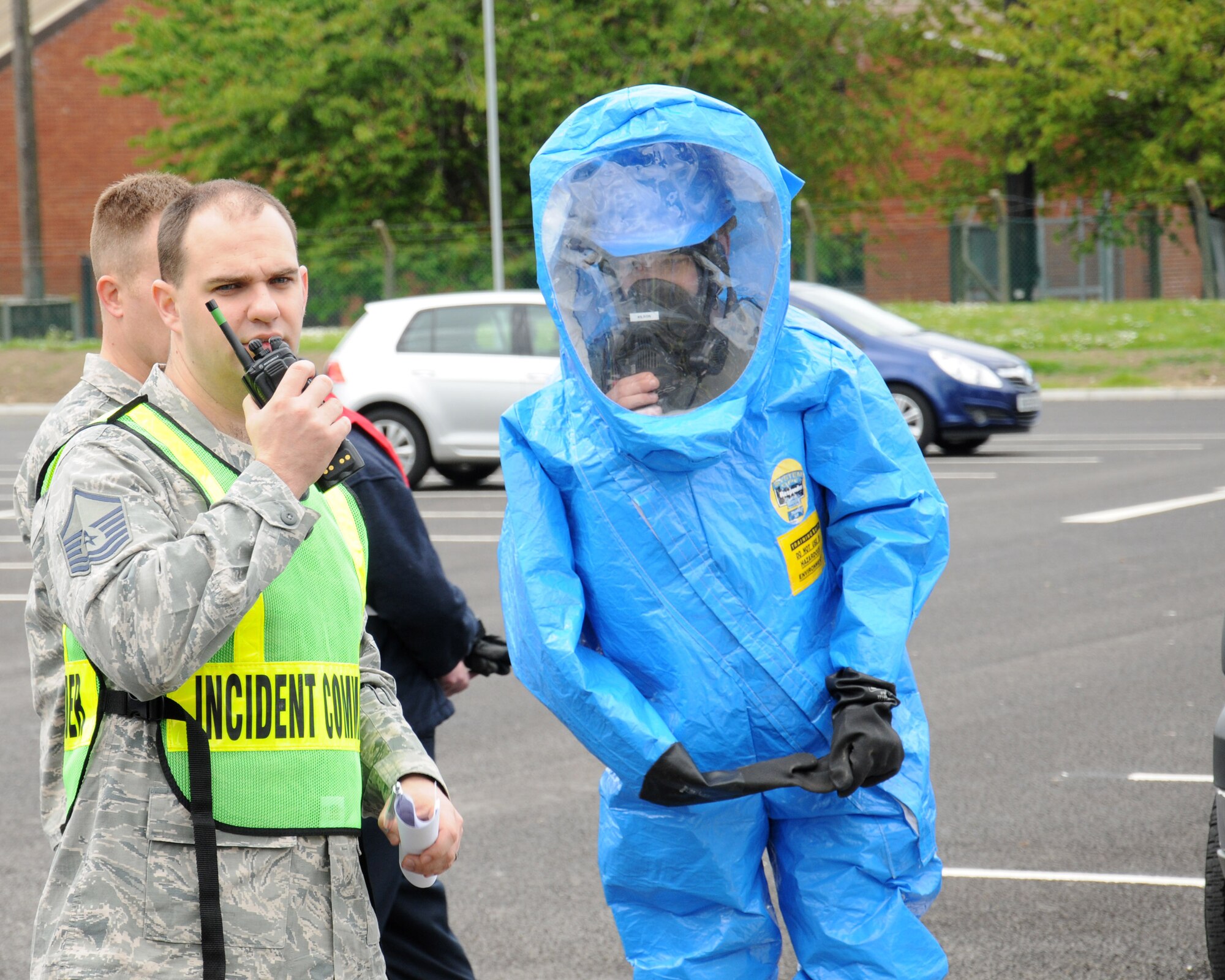 U.S. Air Force Master Sgt. Robert Peterson, left, 100th Civil Engineer Squadron Fire Department assistant chief from Hudson, Mass., uses a radio to communicate with his team during a hazardous material exercise May 6, 2014, on RAF Mildenhall, England. The base exercises regularly to ensure emergency responders remain proficient for any real-world incidents. (U.S. Air Force photo by Gina Randall/Released)