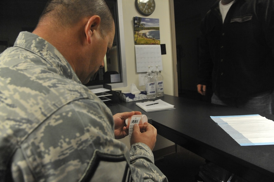 U.S. Air Force Master Sgt. Todd Schafer, 509th Bomb Wing drug testing program administrative manager, places lab label on a member’s specimen bottle at Whiteman Air Force Base, Mo., April 30, 2014. This procedure is done to prepare the bottle for collection and shipping to Lackland Air Force Base, Texas. (U.S. Air Force photo by Airman 1st Class Keenan Berry/Released) 